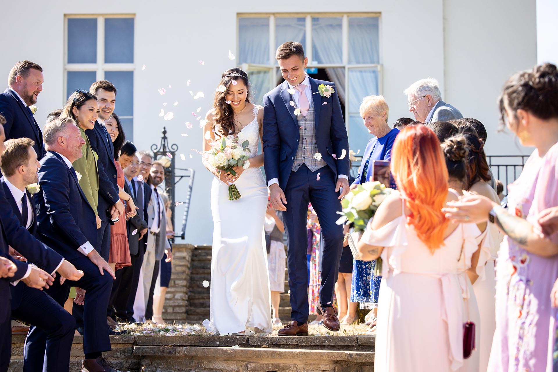 Bride and groom with confetti at Hylands Estate Chelmsford by Essex wedding photographer