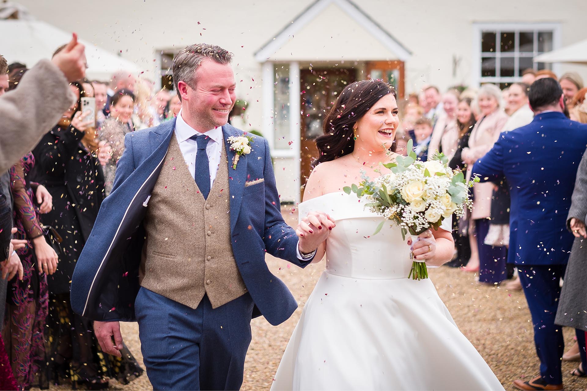 Bride and groom with confetti by Essex reportage wedding photographer at The Compasses at Pattiswick