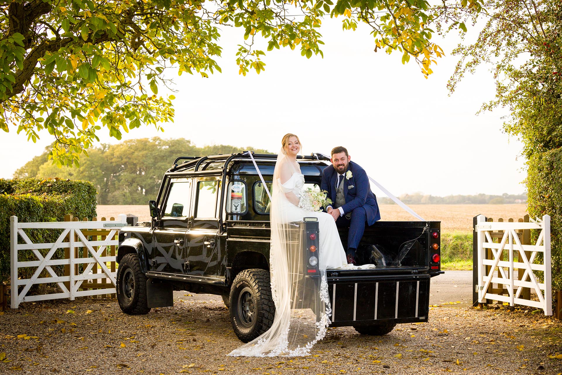 Bride and groom with Land Rover by Essex wedding photographer at The Compasses at Pattiswick