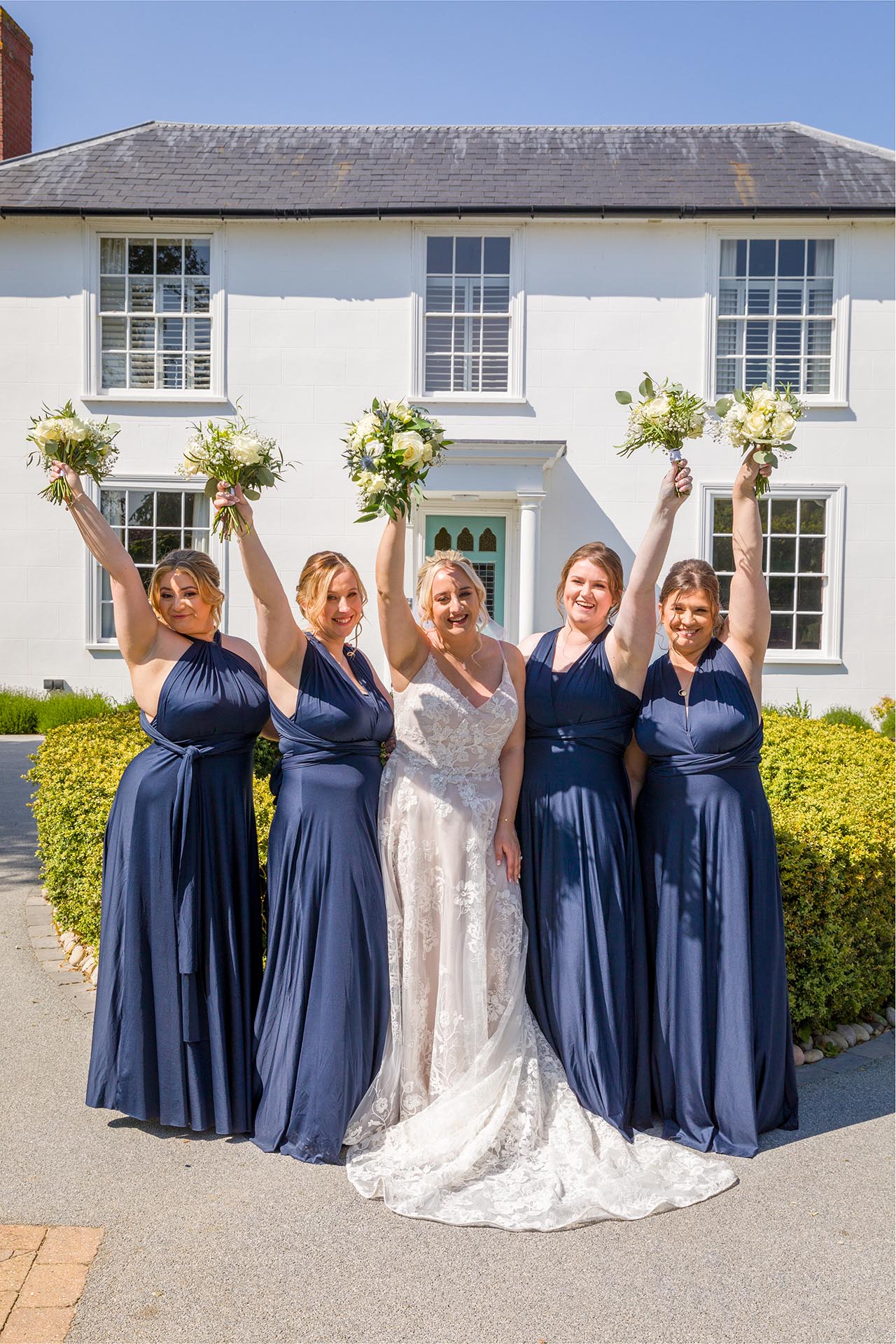 Bride and bridesmaids celebrating by Essex wedding photographer at Vaulty Manor Maldon