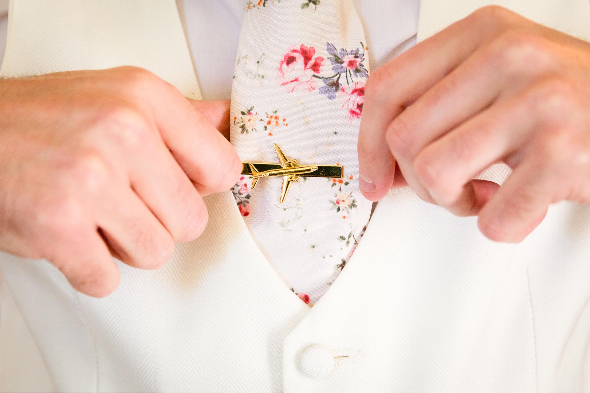 Detail of groom's aeroplane tie clip before the wedding ceremony at Leez Priory, Great Leighs, Chelmsford by Essex wedding photographer