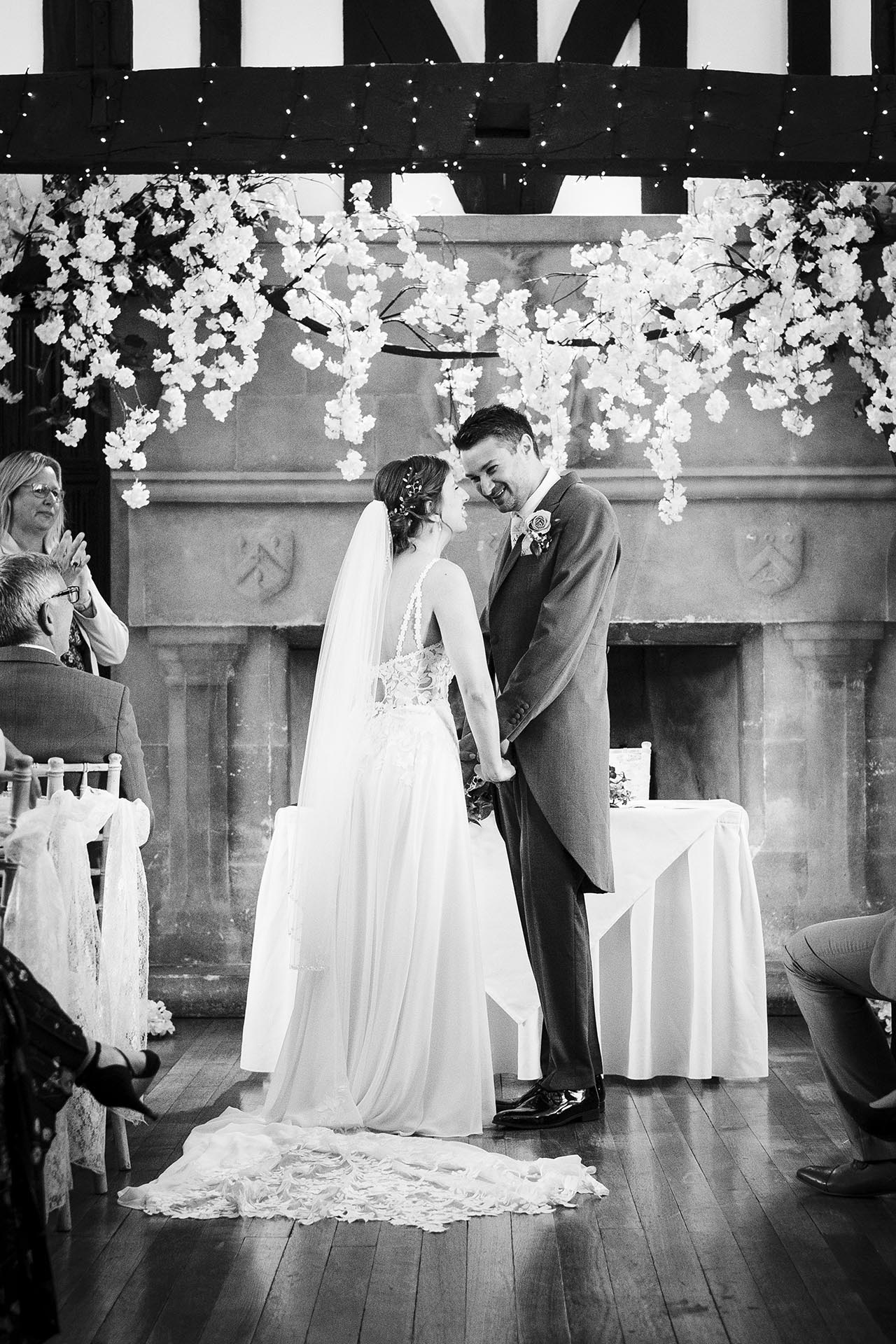Black and white photograph of bride and groom during their wedding ceremony at Leez Priory, Great Leighs, Chelmsford by Essex wedding photographer