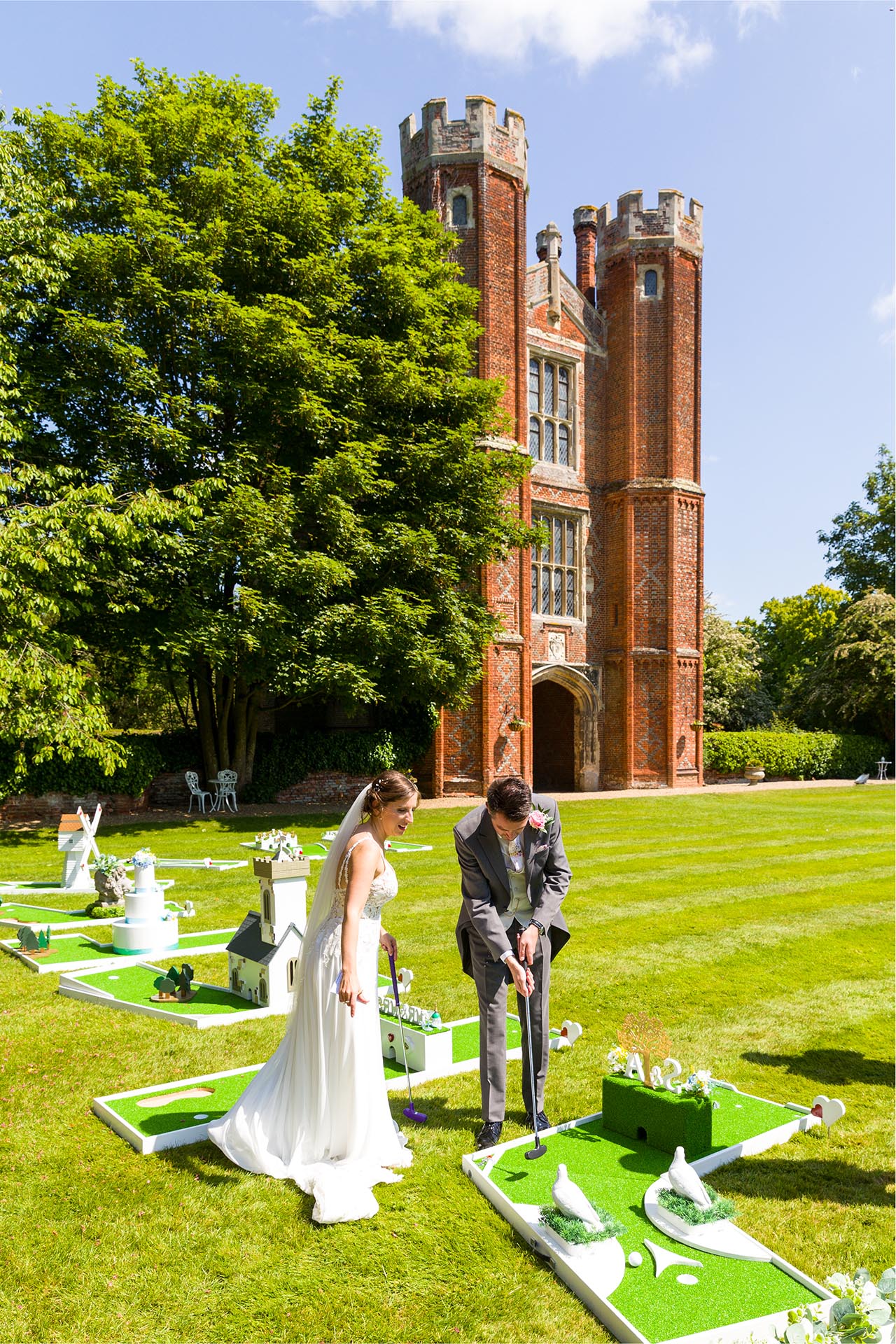 Bride and groom playing crazy golf at Leez Priory, Great Leighs, Chelmsford, by Essex wedding photographer