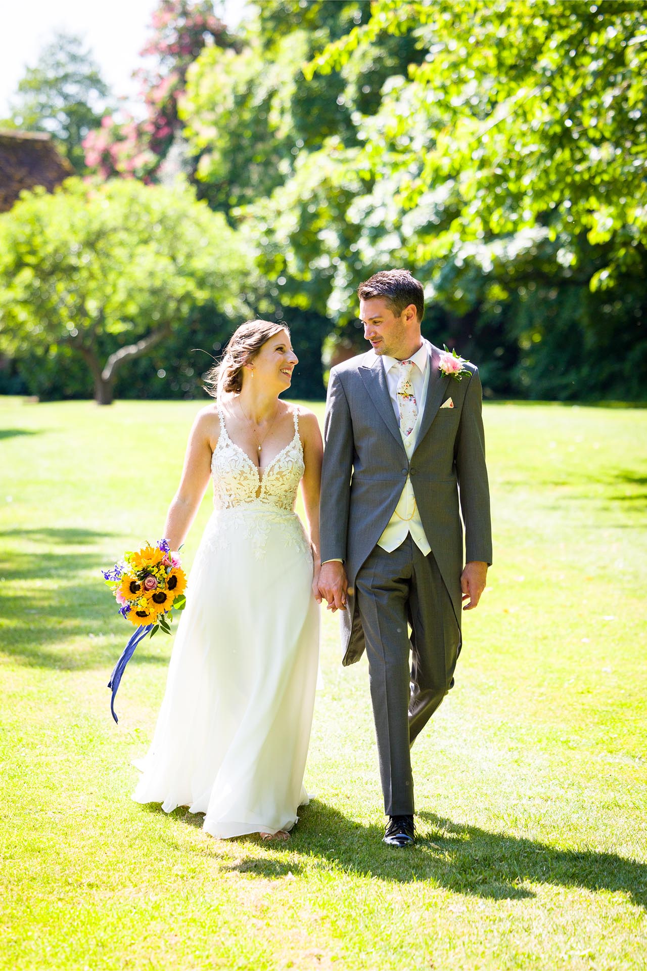 Bride and groom walking through the grounds at a Leez Priory wedding, Great Leighs, Chelmsford, by Essex wedding photographer