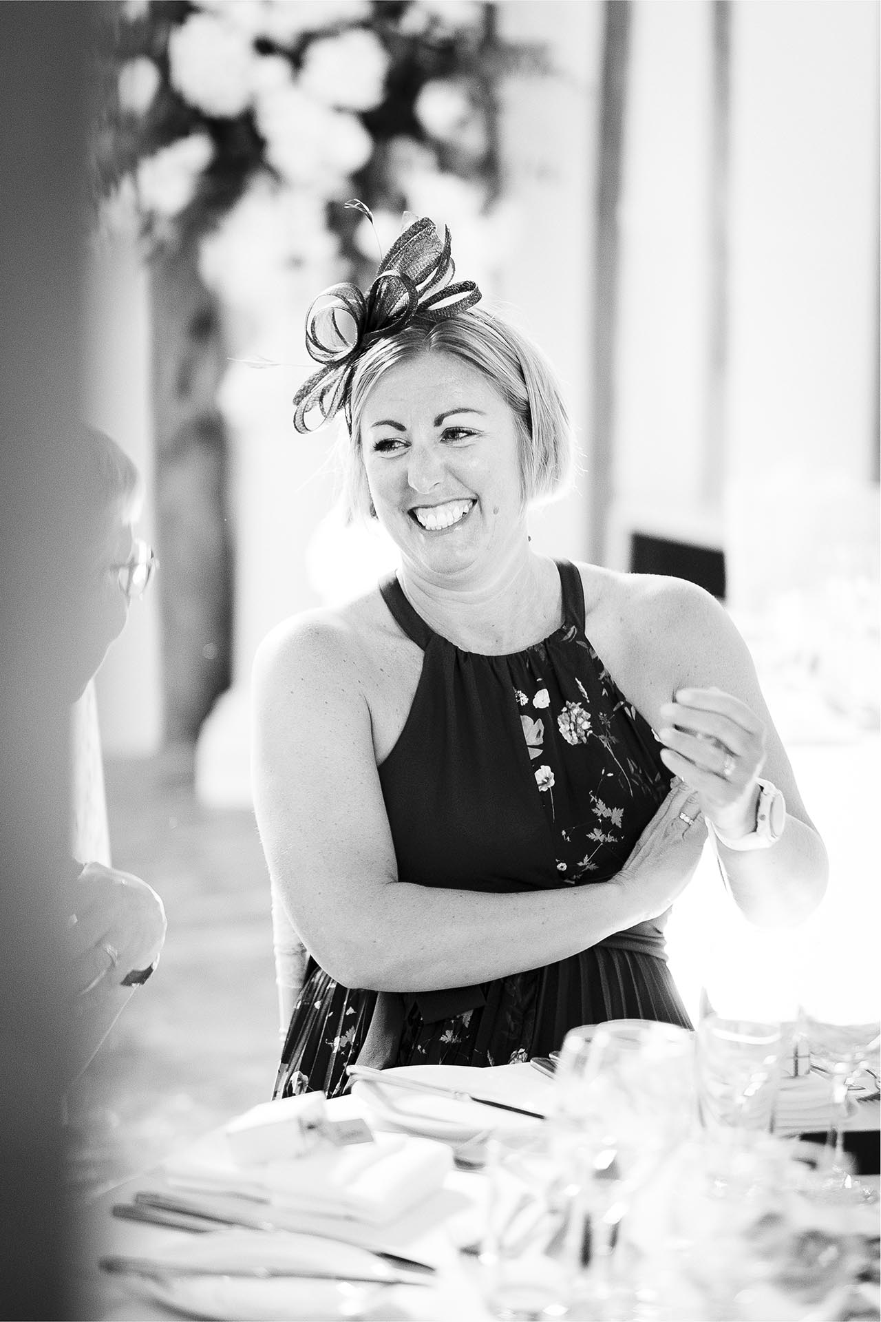 Black and white photograph of guests during wedding breakfast at Leez Priory, Great Leighs, Chelmsford, by Essex wedding photographer