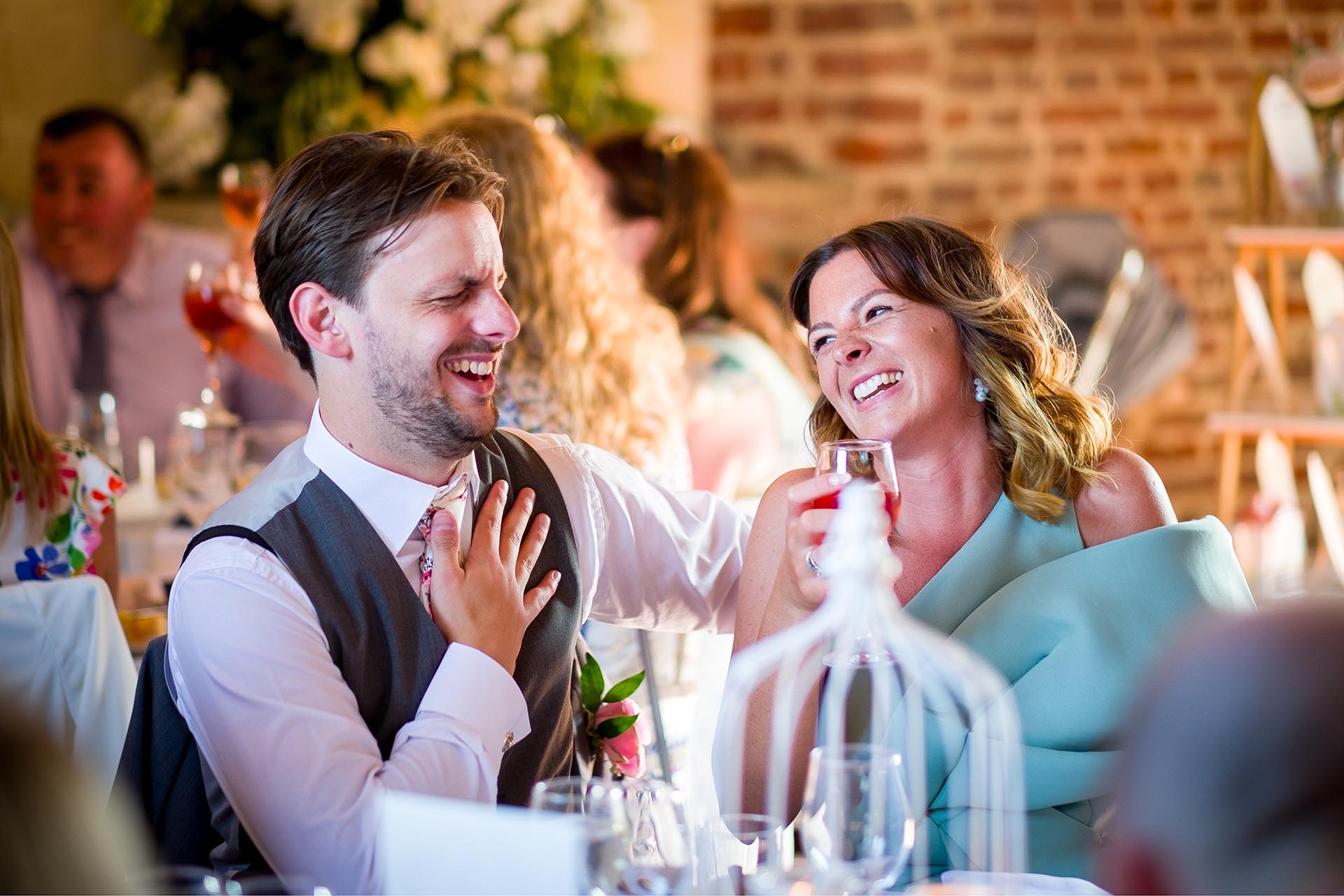 Guests laughing during wedding breakfast at Leez Priory, Great Leighs, Chelmsford, by Essex wedding photographer