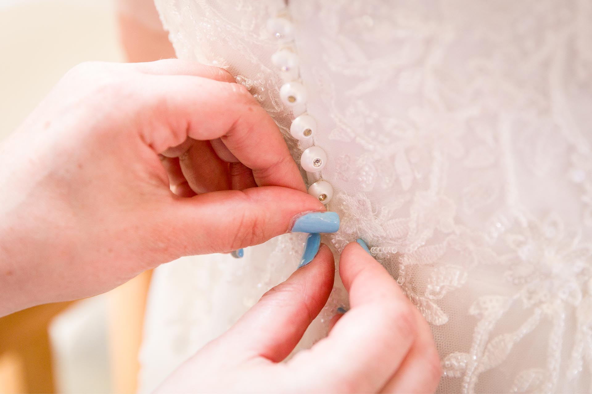 Close up photograph of buttons on the bride's dress at Apton Hall, Rochford, Essex