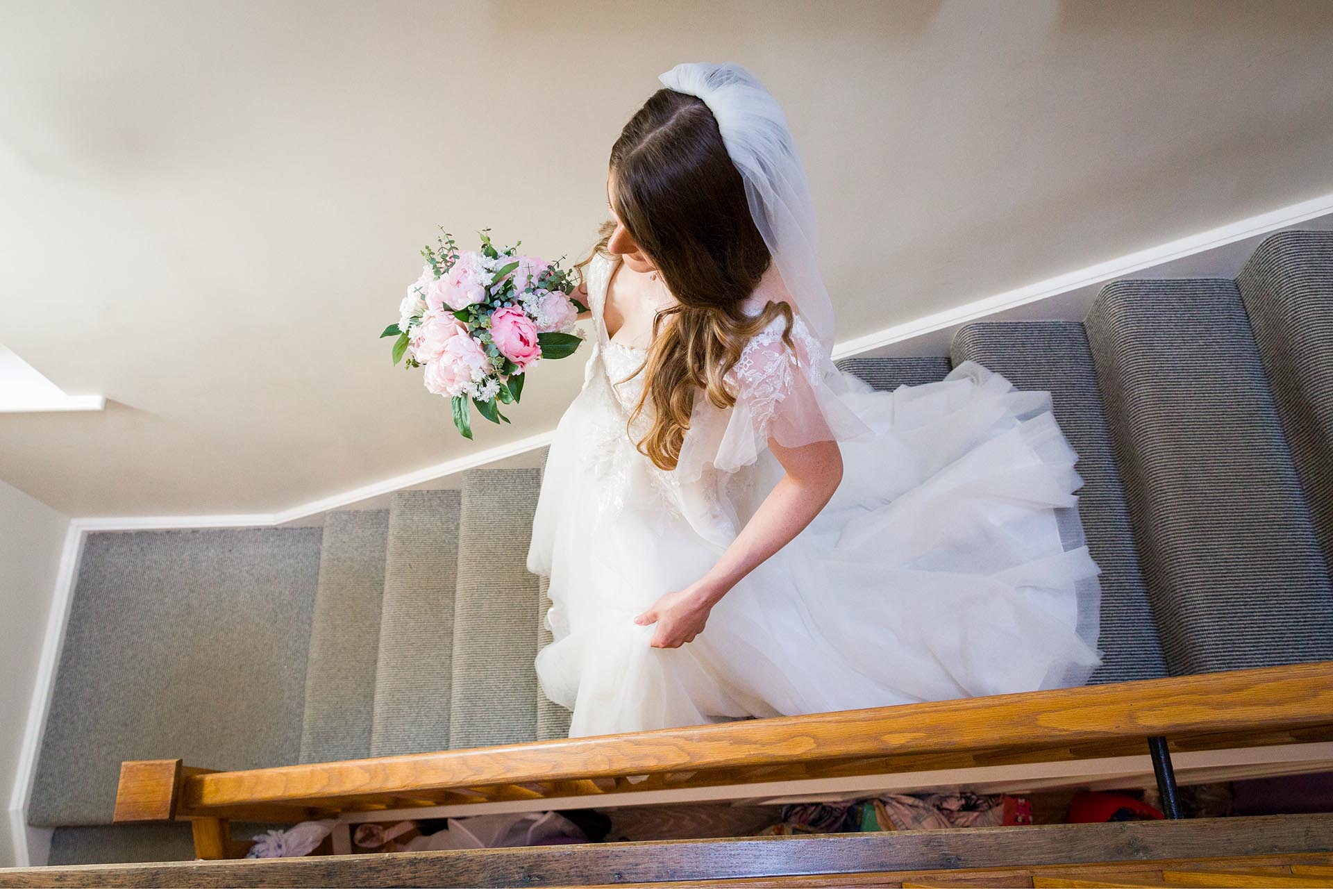 Photograph of the bride going downstairs at Apton Hall, Rochford, Essex