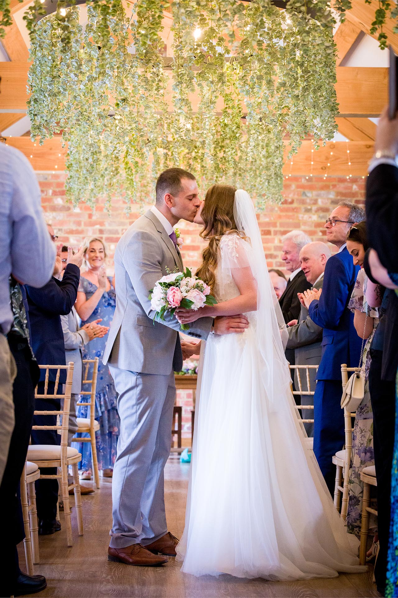 Photograph of the bride and groom kissing in ceremony room at Apton Hall, Rochford, Essex