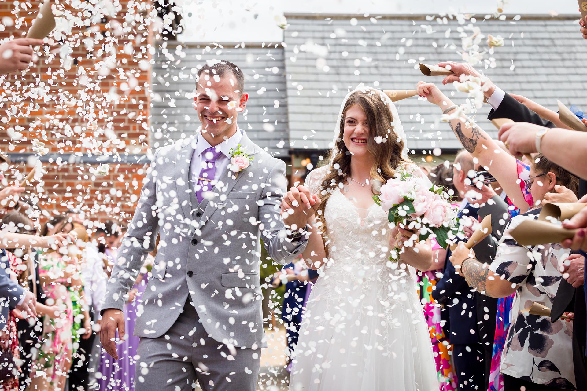Photograph of the bride and groom walking through confetti at Apton Hall, Rochford, Essex