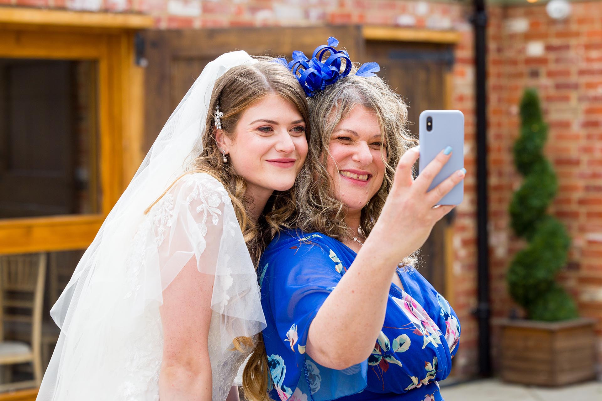 Candid photograph of the bride and her mother taking a selfie at Apton Hall, Rochford, Essex