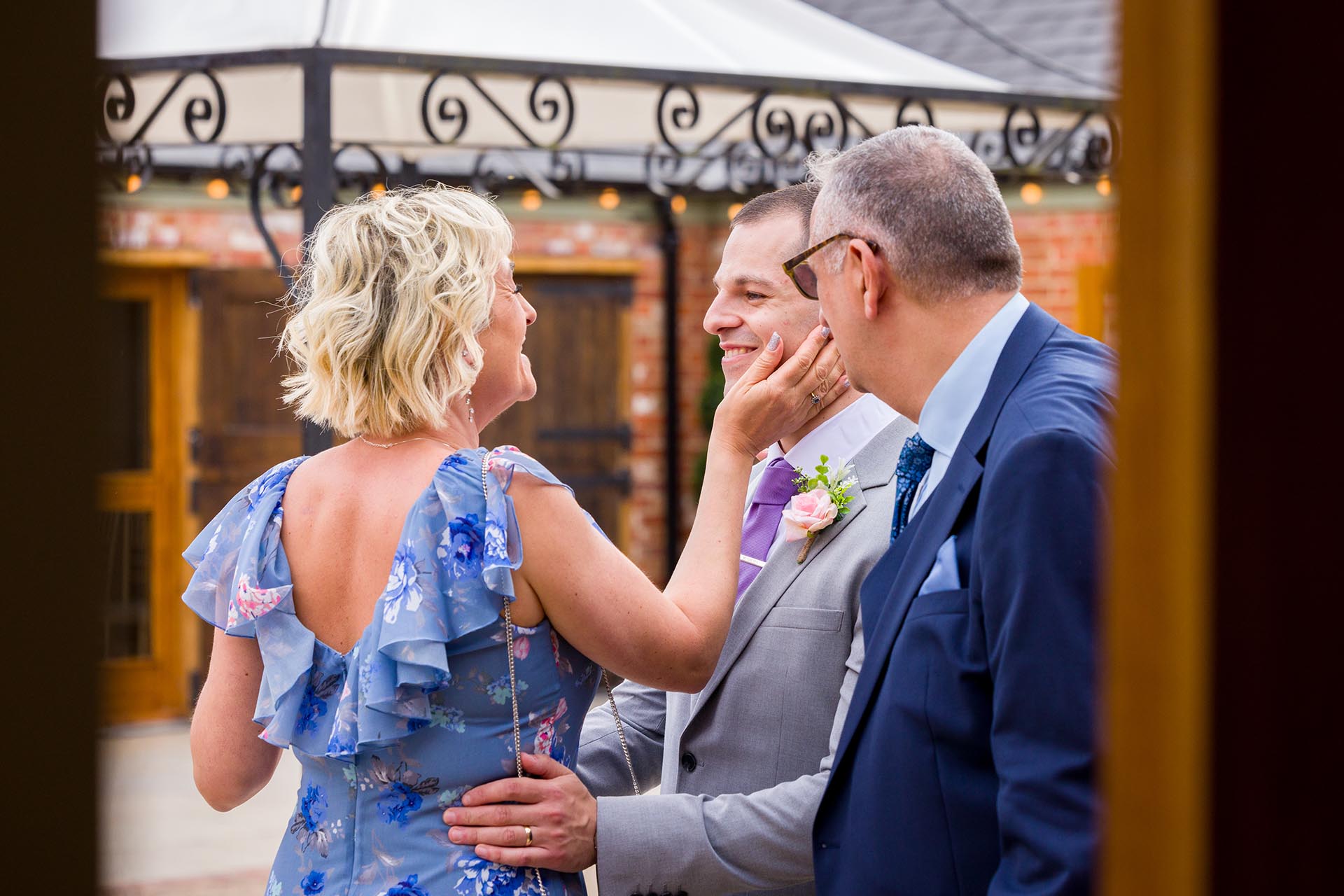 Candid photograph of the groom with family at Apton Hall, Rochford, Essex