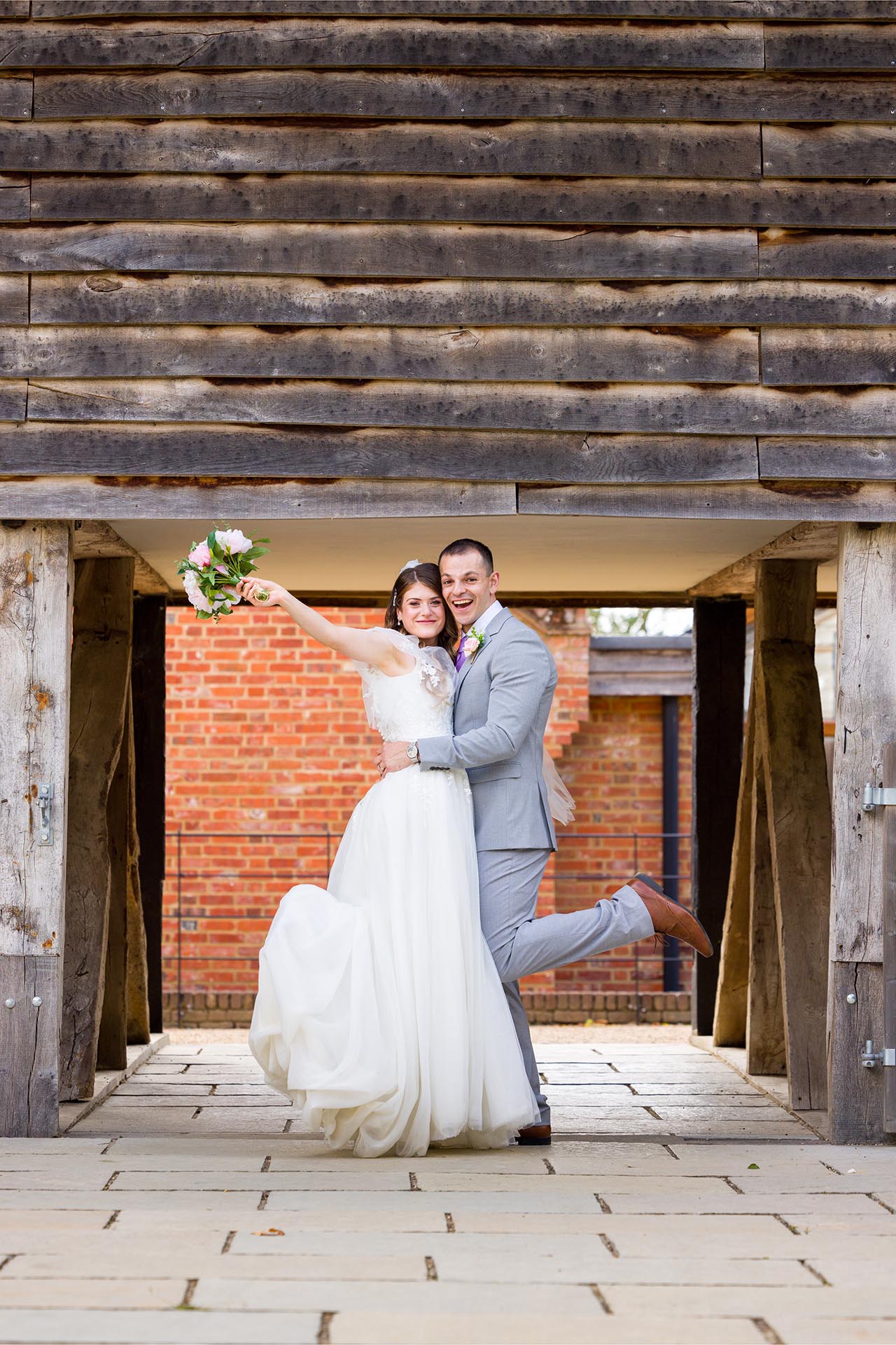 Photograph of the bride and groom cheering at Apton Hall, Rochford, Essex