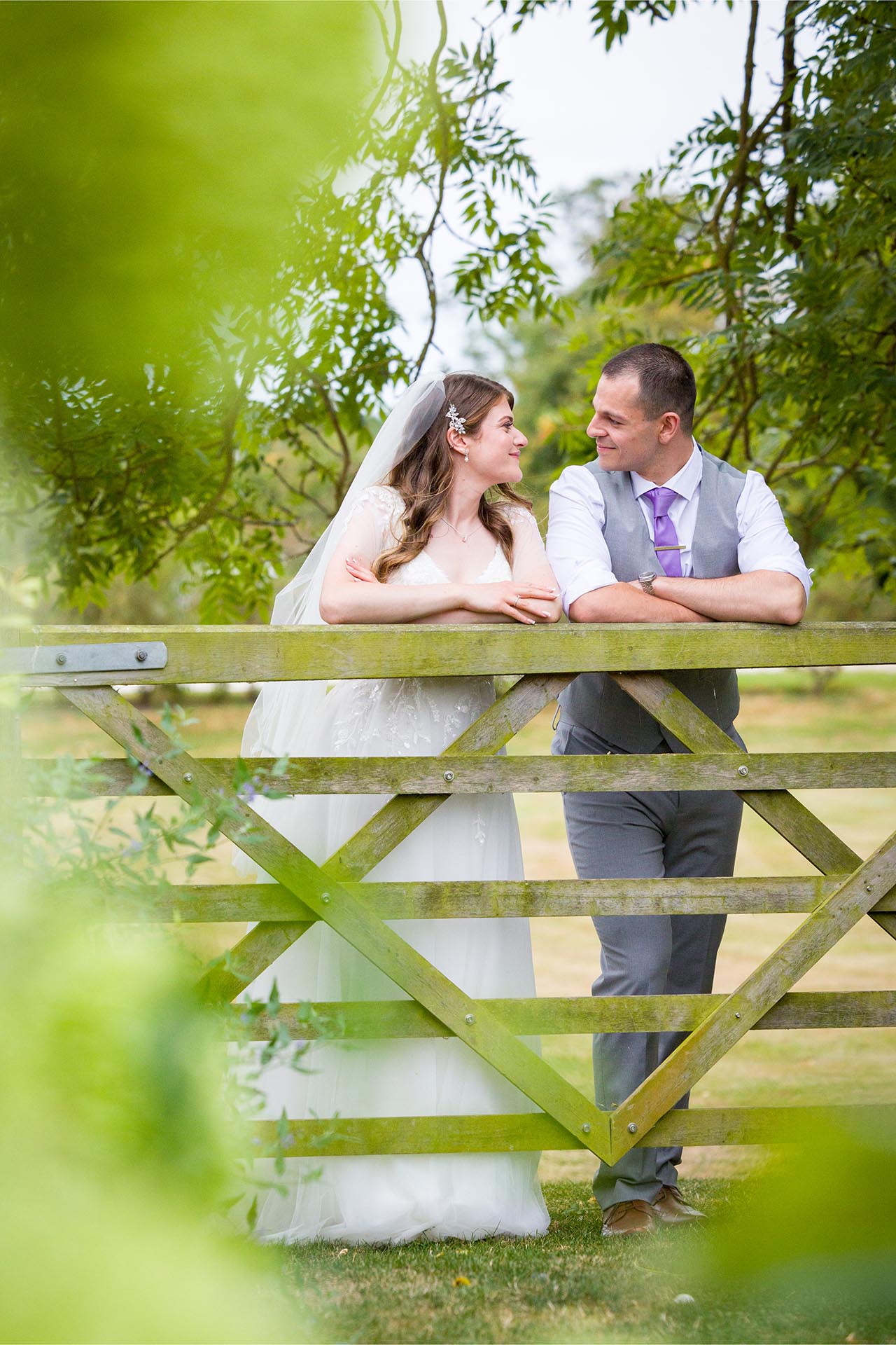 Photograph of a bride and groom leaning on a gate at Apton Hall, Rochford, Essex