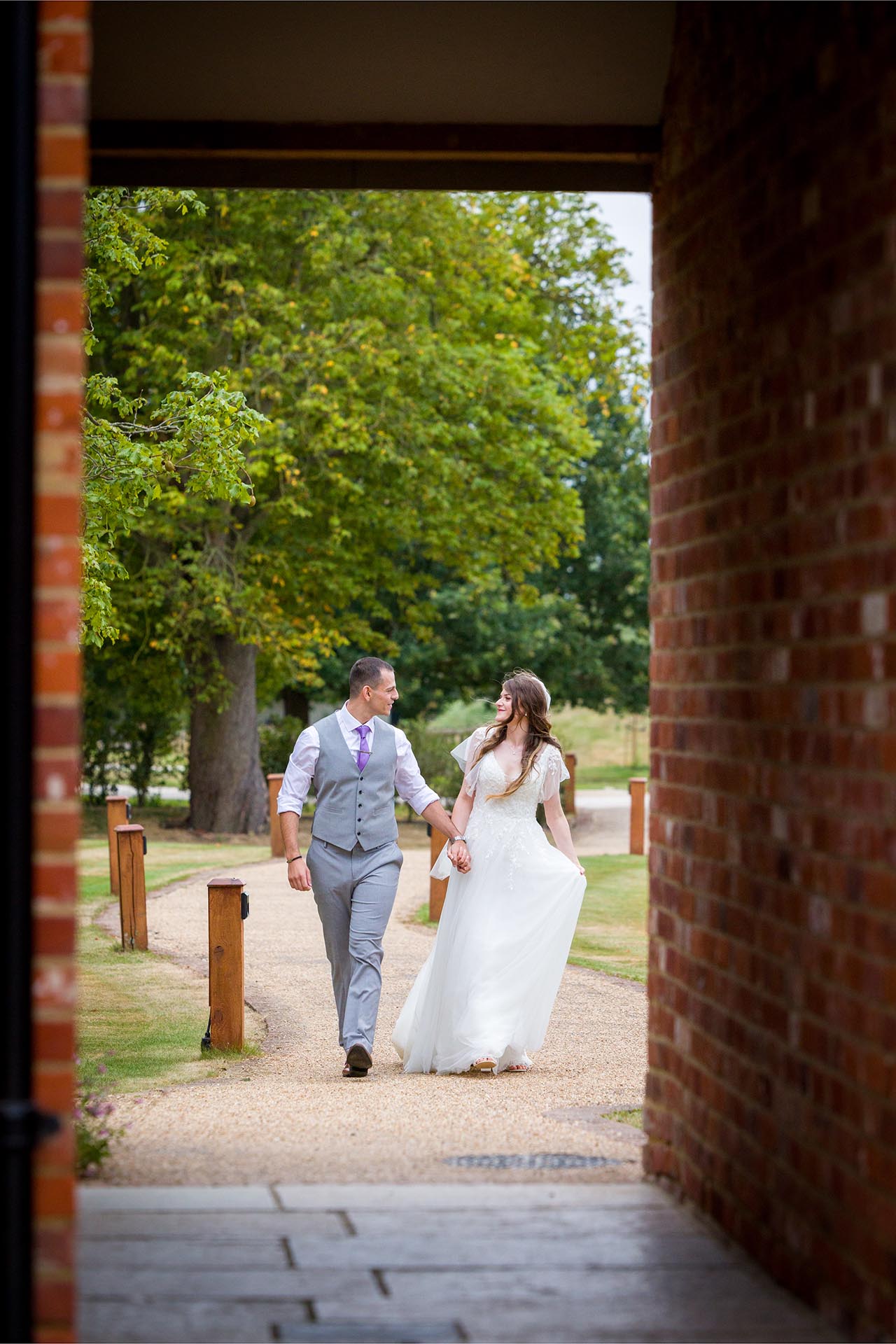 Photograph looking through a brick passageway of a bride and groom at Apton Hall, Rochford, Essex