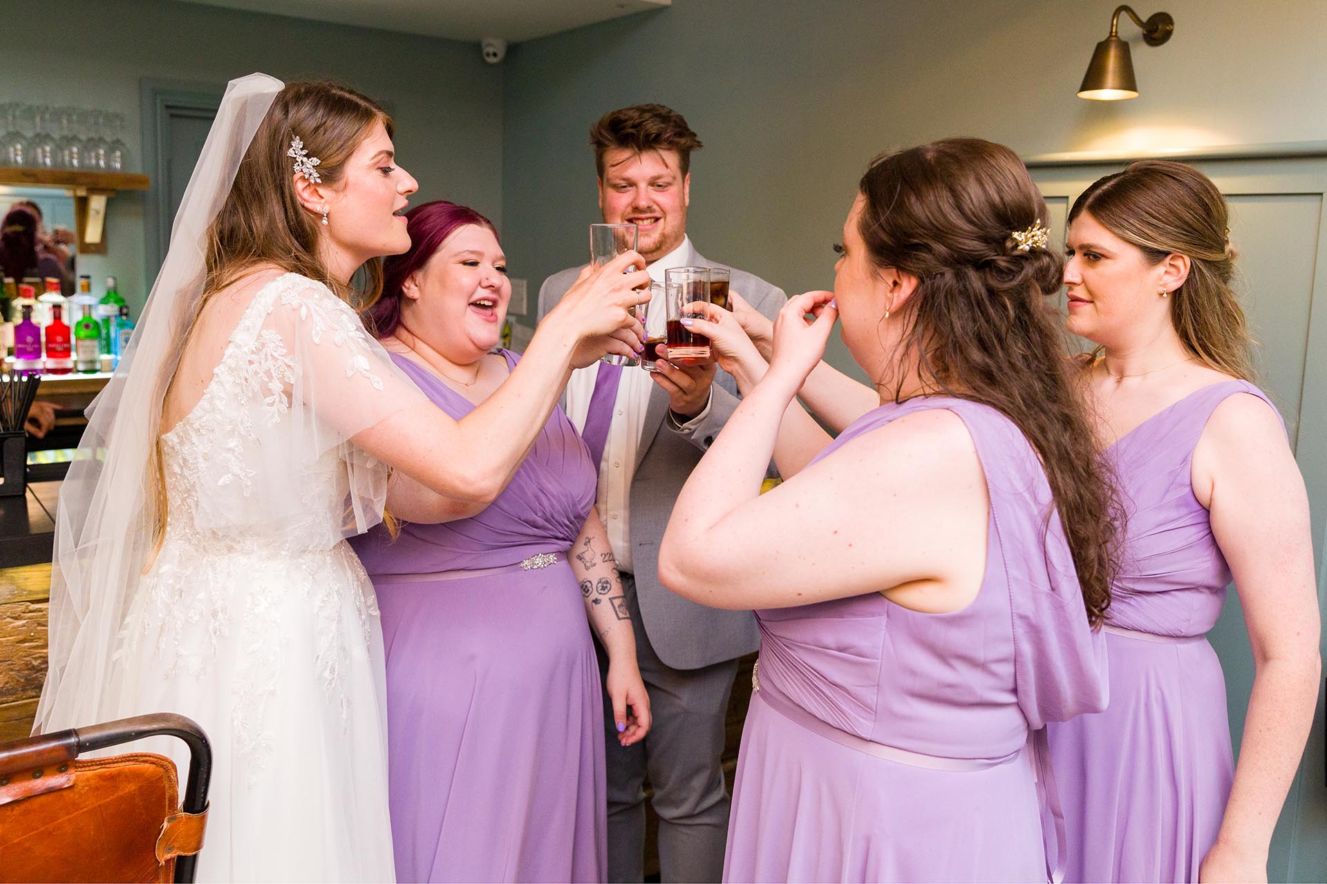 Photograph of a bride sharing a toast with bridesmaids at Apton Hall, Rochford, Essex