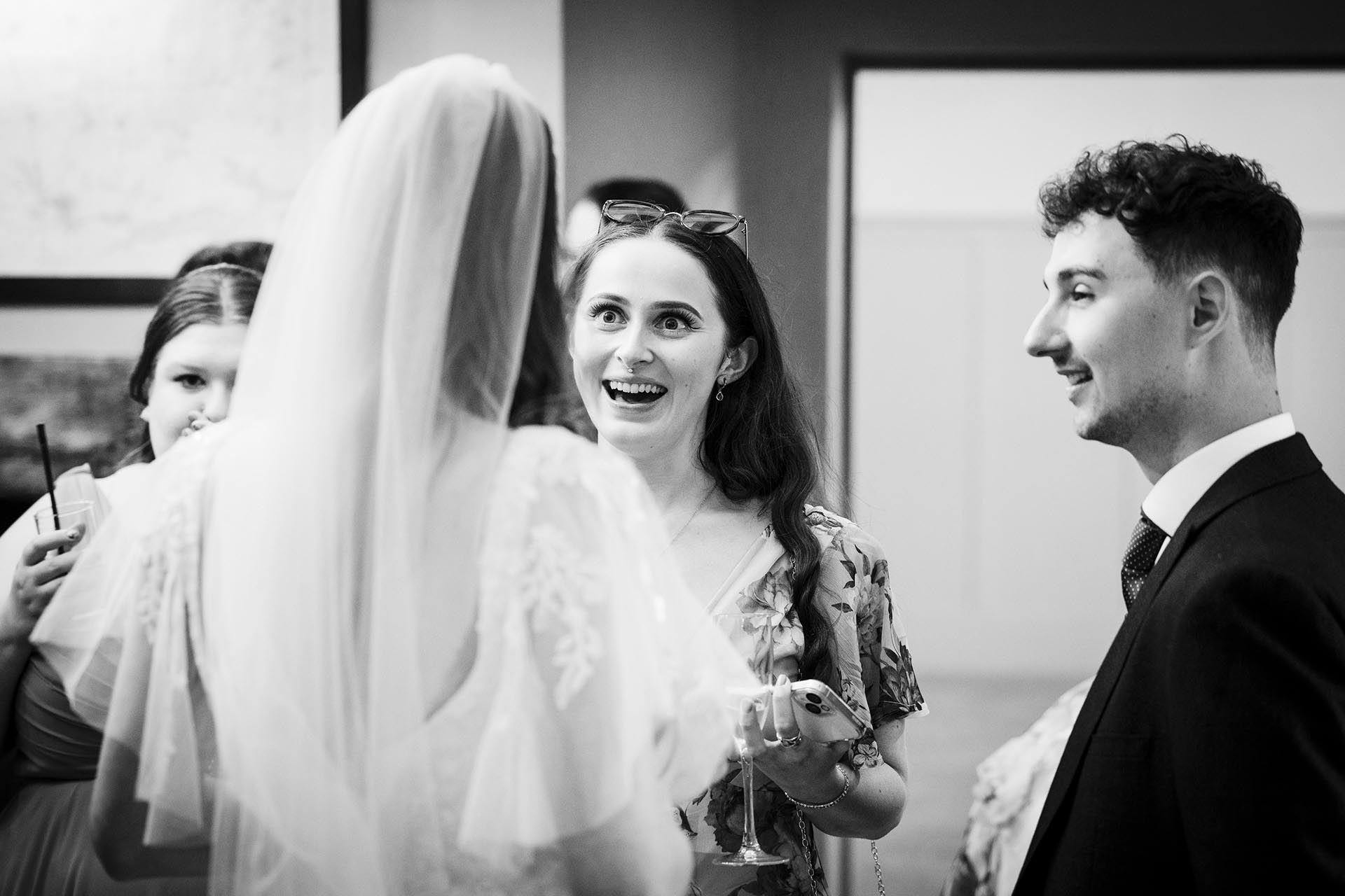 Black and white photograph of a happy wedding guest at Apton Hall, Rochford, Essex