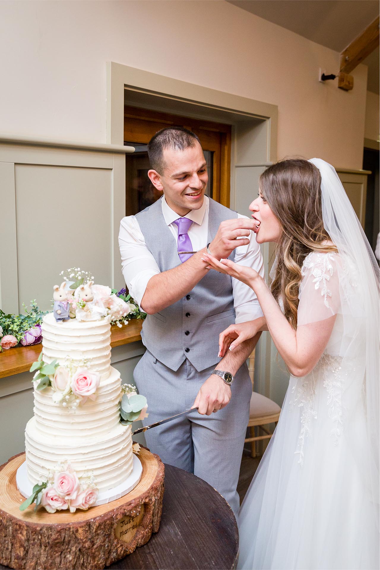 Photograph of groom giving bride some cake at Apton Hall, Rochford, Essex