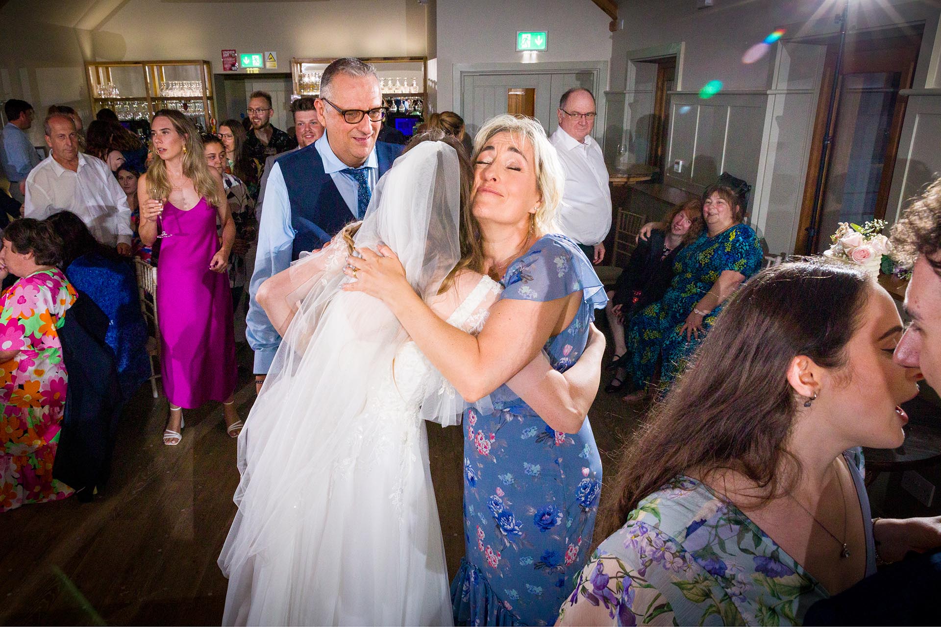 Photograph of bride hugging family at Apton Hall, Rochford, Essex