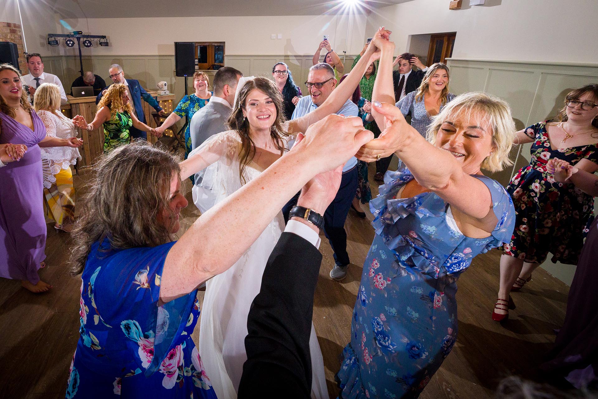 Colourful photograph of bride and guests dancing at Apton Hall, Rochford, Essex