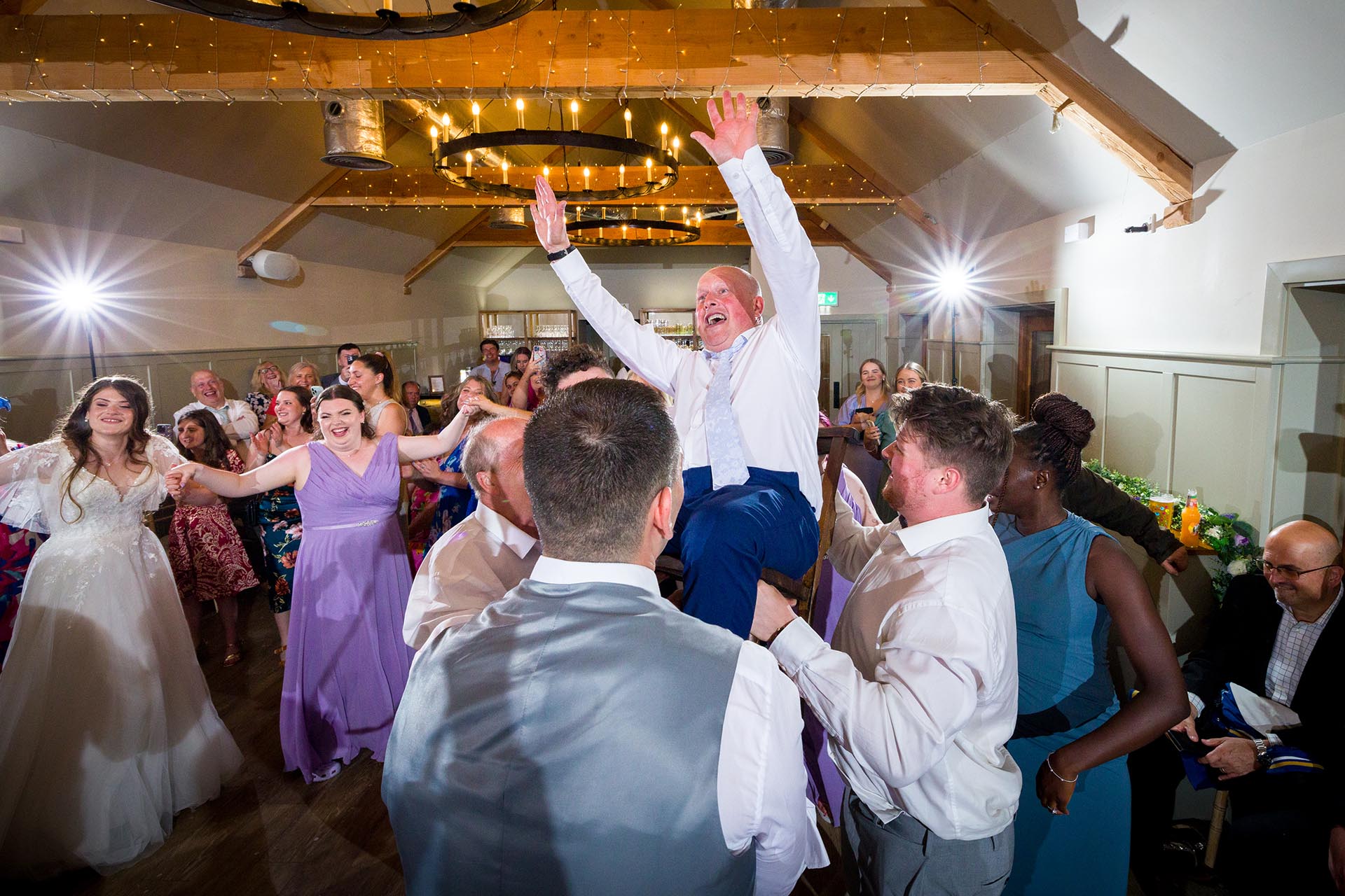 Colourful photograph of wedding guests dancing at Apton Hall, Rochford, Essex