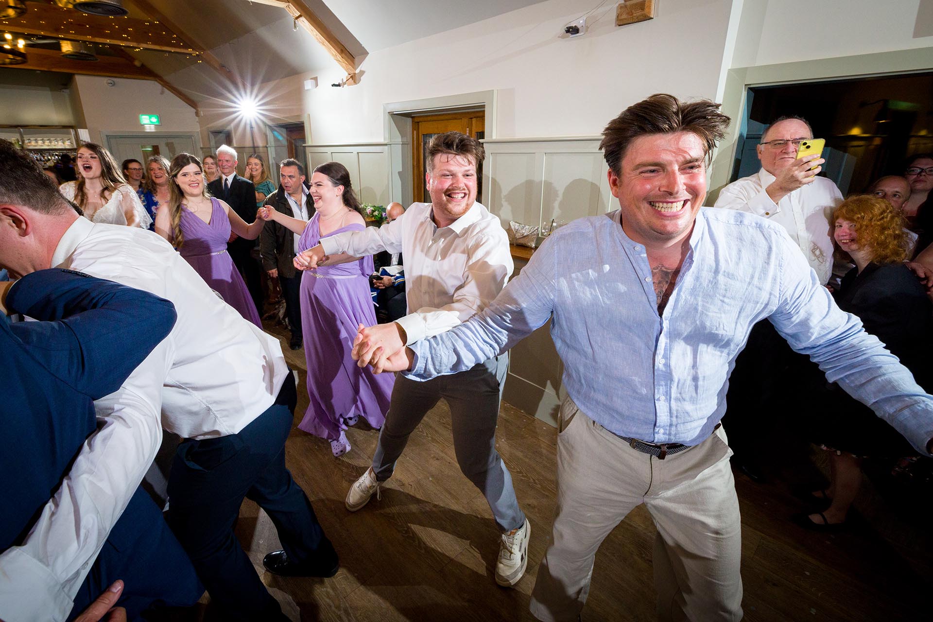 Colourful photograph of wedding guests dancing at Apton Hall, Rochford, Essex