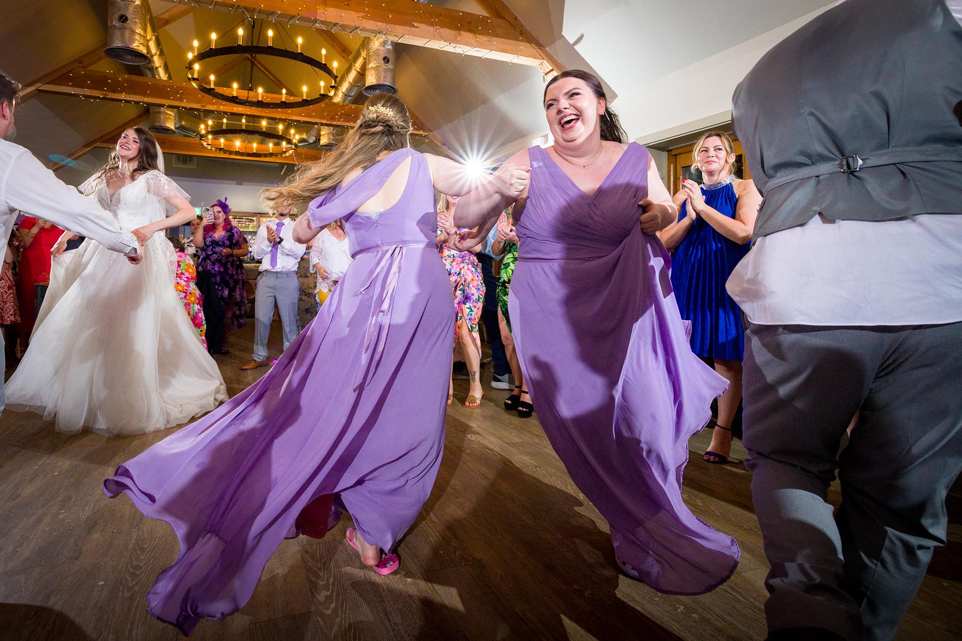Colourful photograph of wedding bridesmaids dancing at Apton Hall, Rochford, Essex