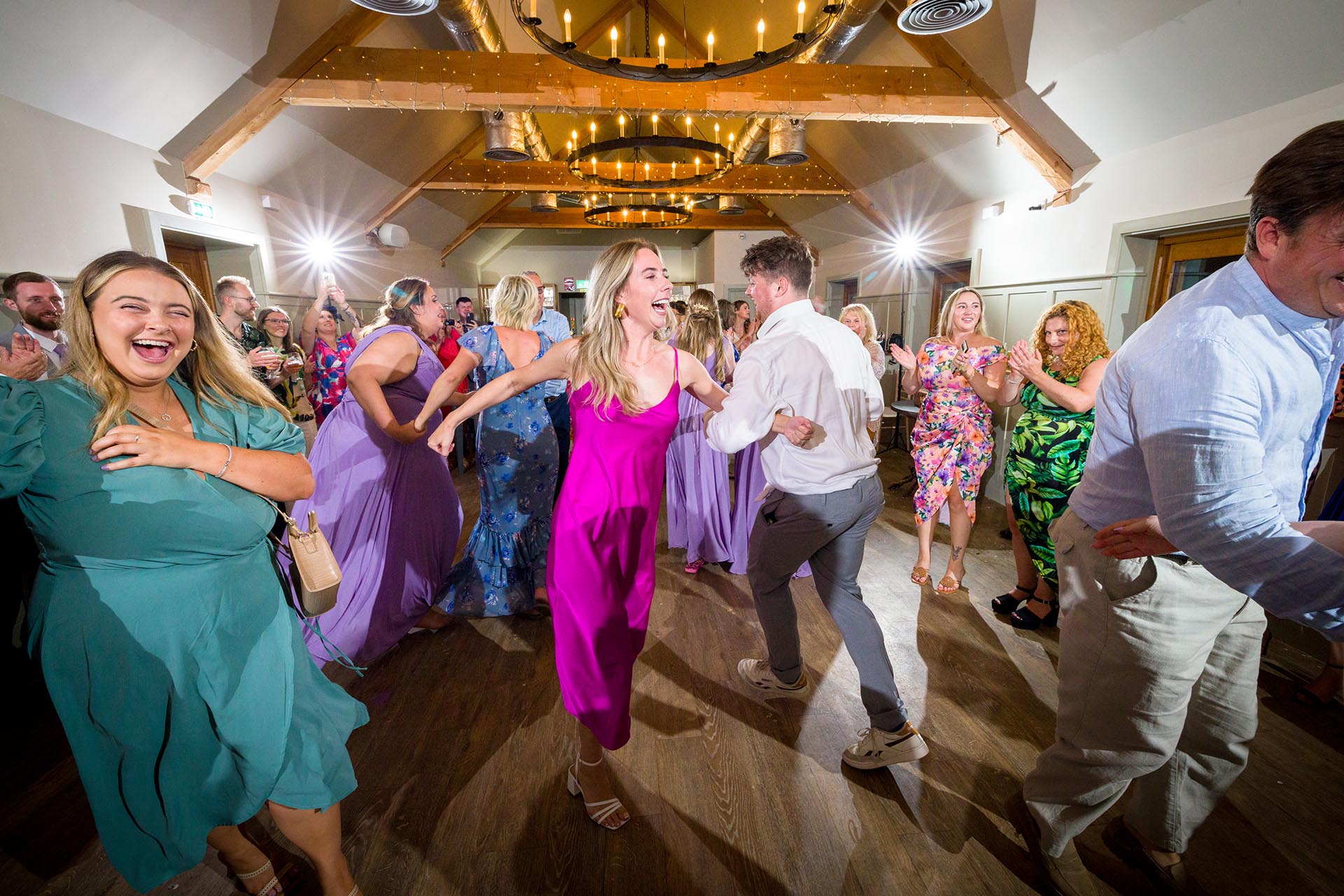Colourful photograph of wedding guests dancing at Apton Hall, Rochford, Essex
