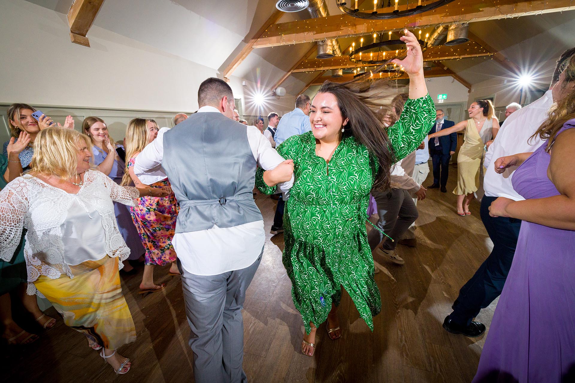 Colourful photograph of wedding guests dancing at Apton Hall, Rochford, Essex