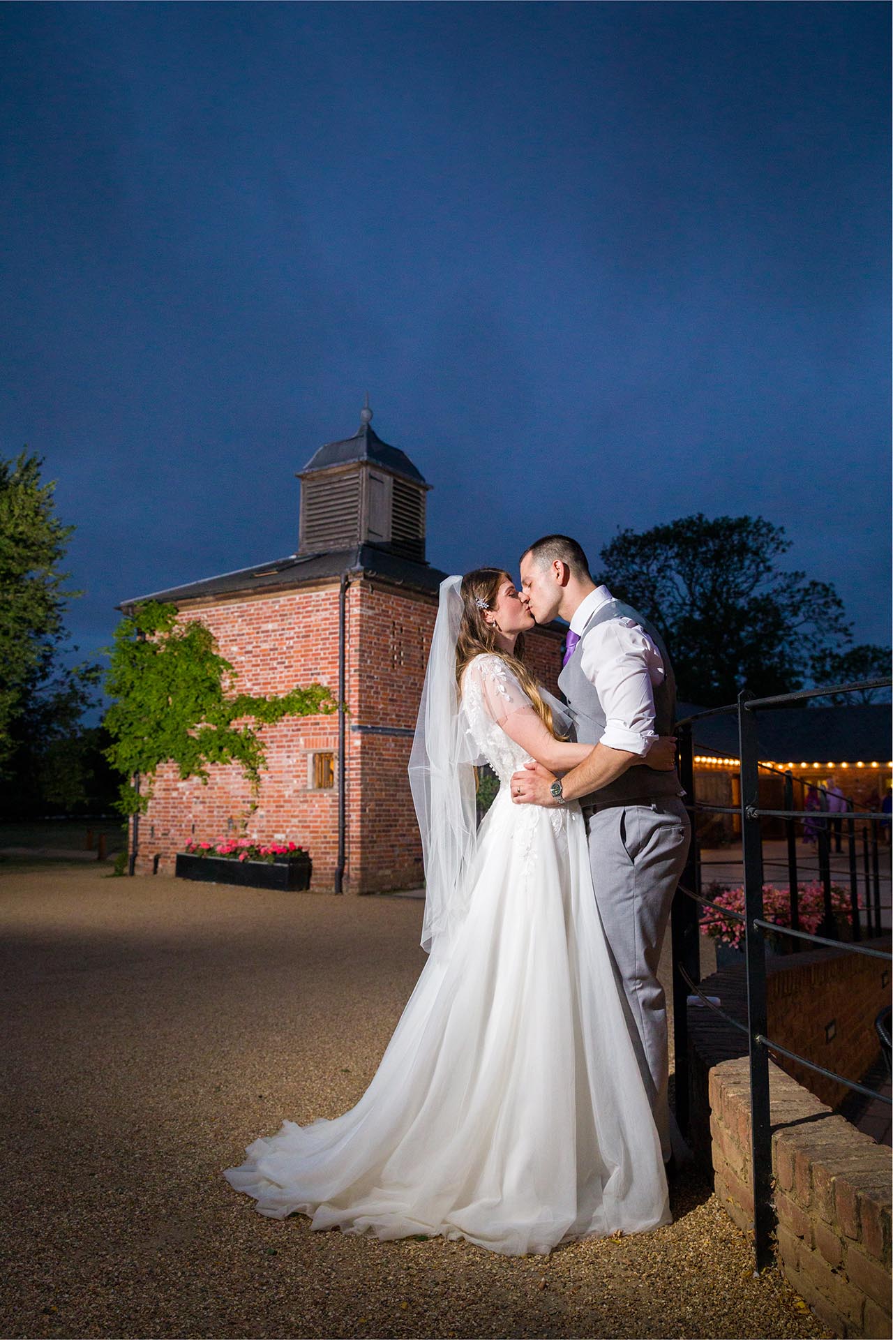 Twilight photograph of bride and groom kissing at Apton Hall, Rochford, Essex.
