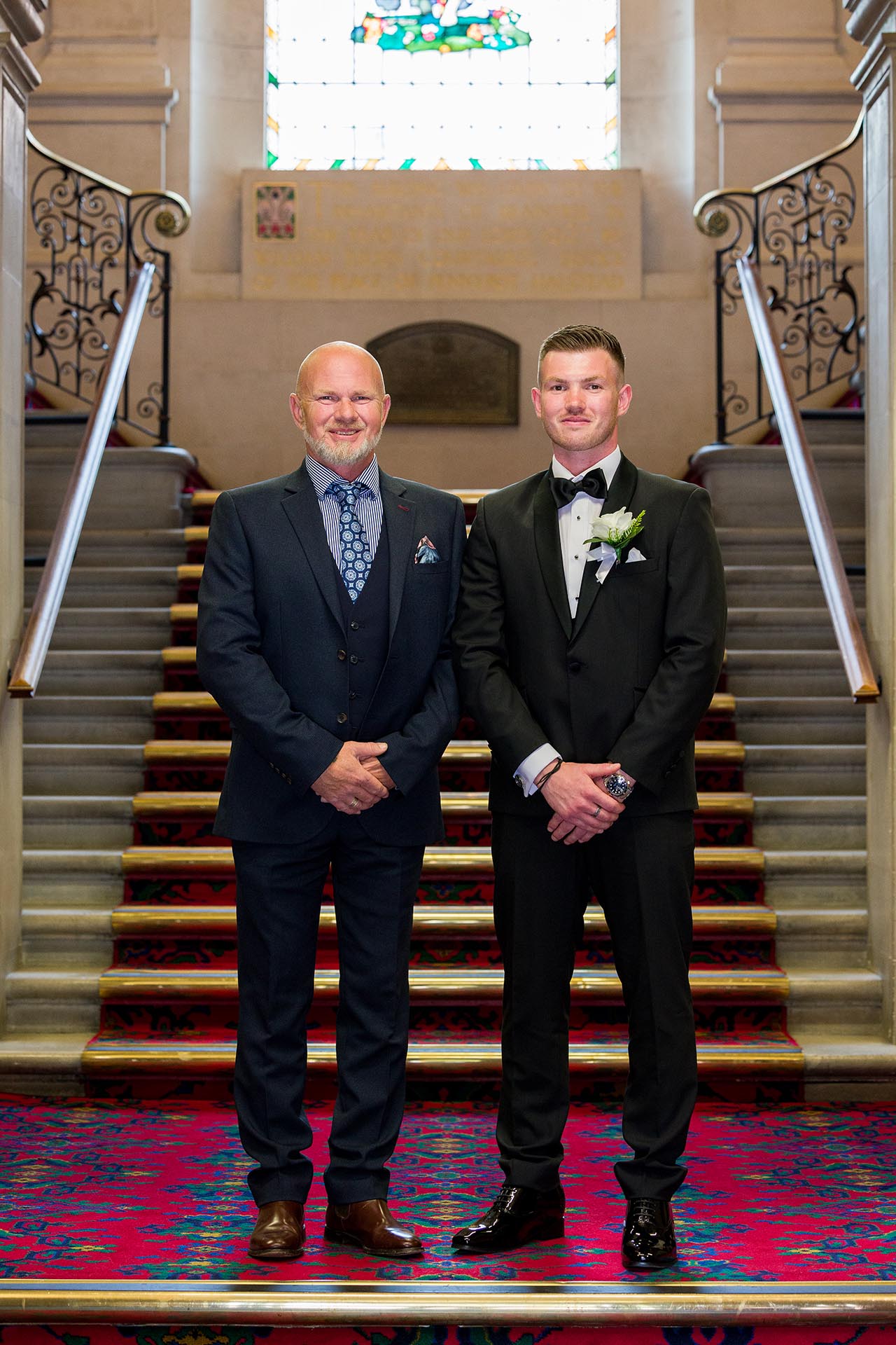 Photograph of groom and his father standing on the staircase at Braintree Town Hall, Braintree, Essex