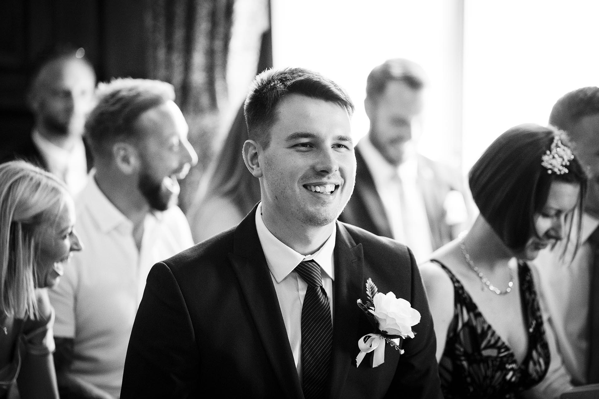 Black and white photograph of wedding guests in the cermony room at Braintree Town Hall, Braintree, Essex