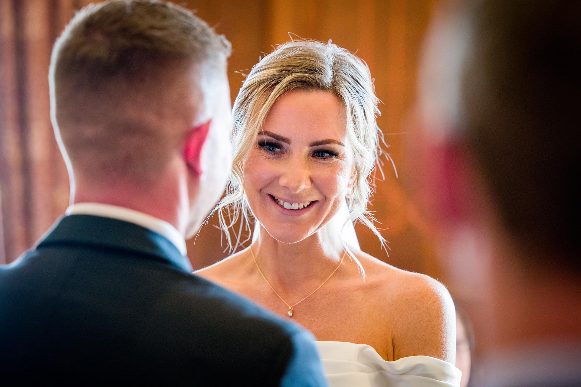 Photograph of bride smiling at her groom during their wedding ceremony at Braintree Town Hall, Braintree, Essex
