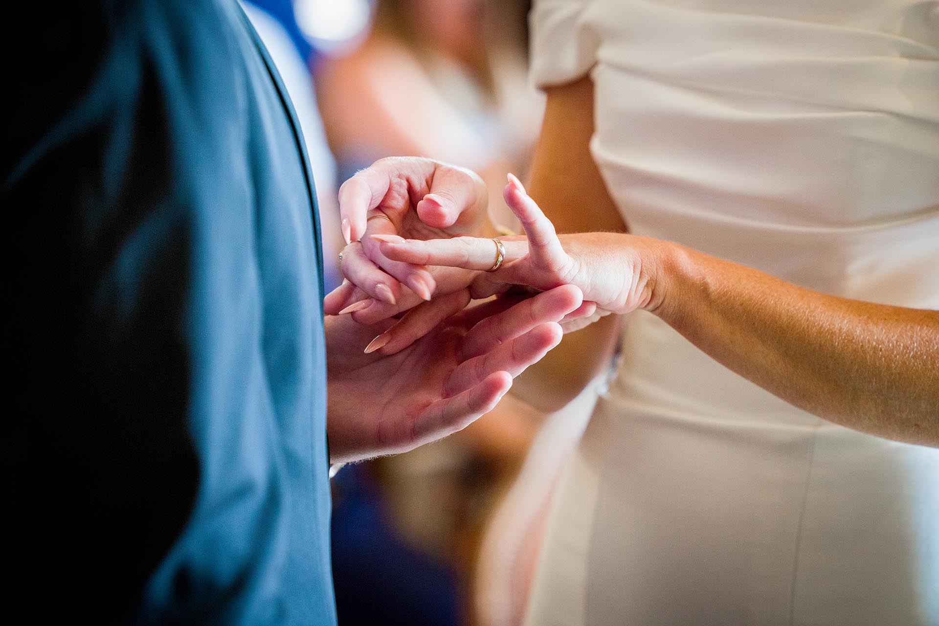 Close-up photograph of a wedding ring on a bride's finger