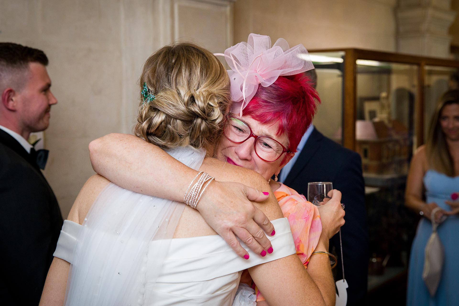 Photograph of a wedding guest hugging a bride