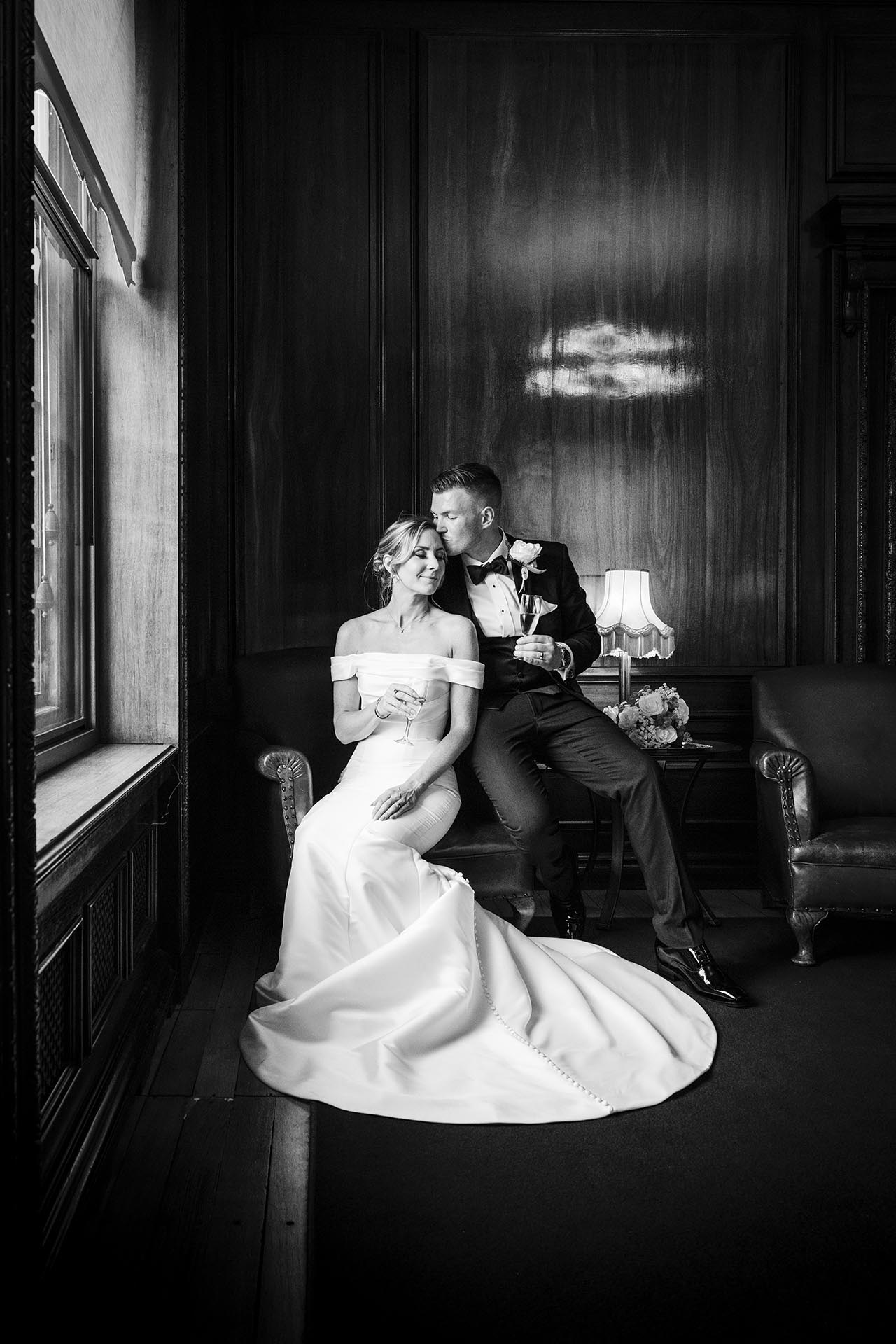 Black and white photograph of the groom kissing the bride at Braintree Town Hall, Braintree, Essex