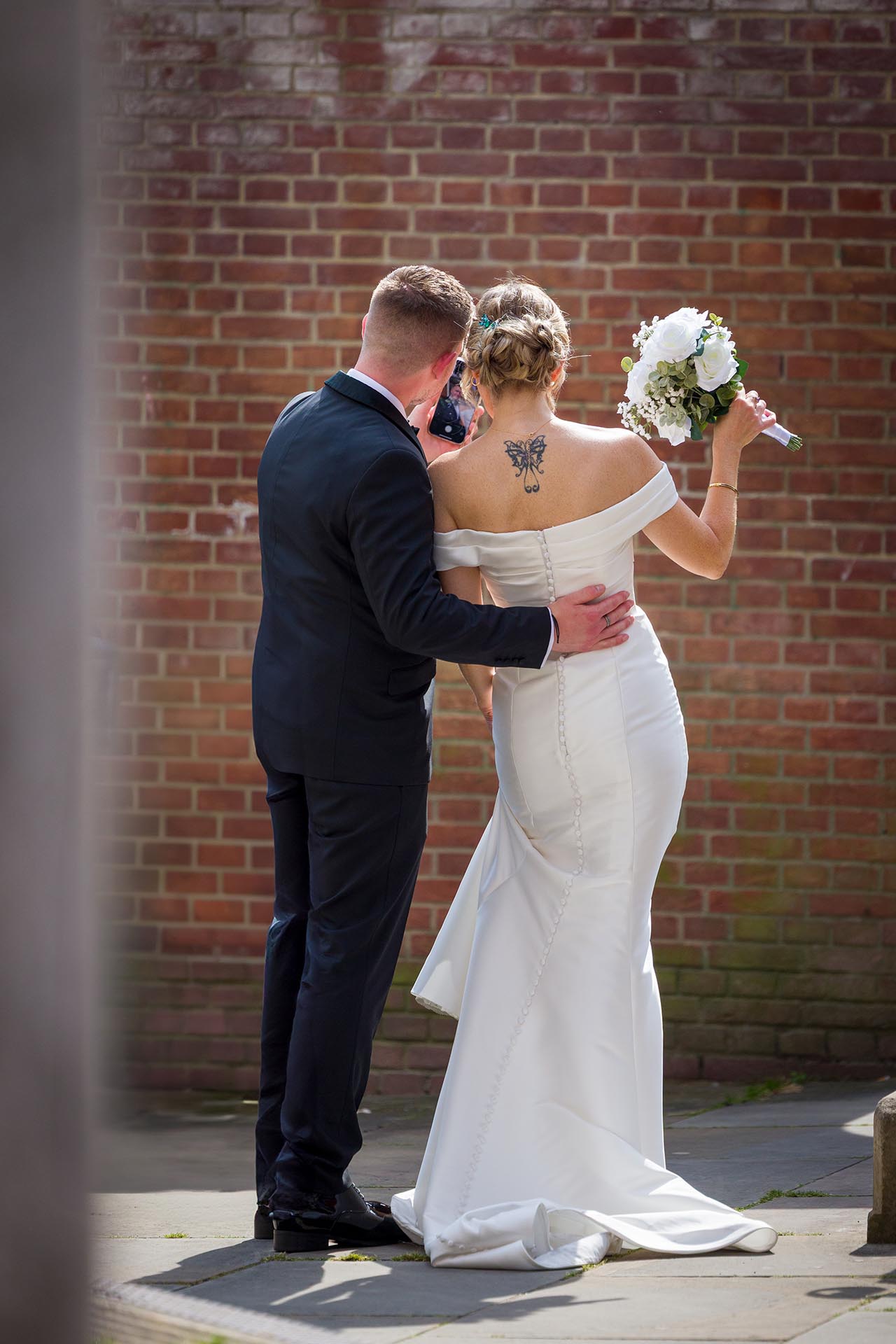 Candid photograph of the bride and groom taking a selfie