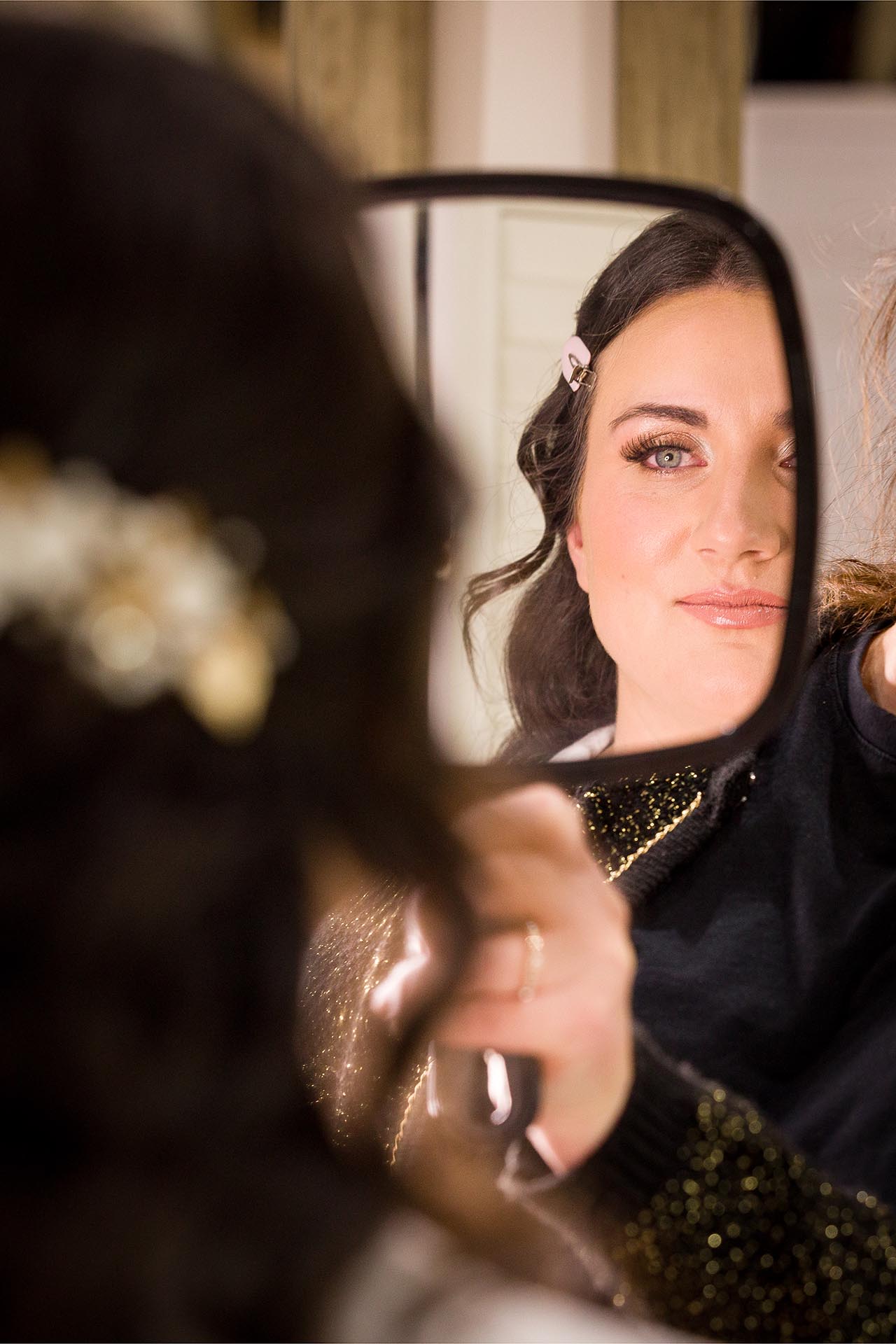 Photograph of bride checking her make-up in a hand-mirror