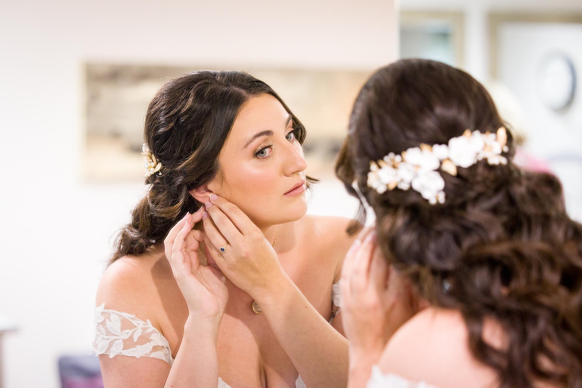 Photograph of bride putting in an earring