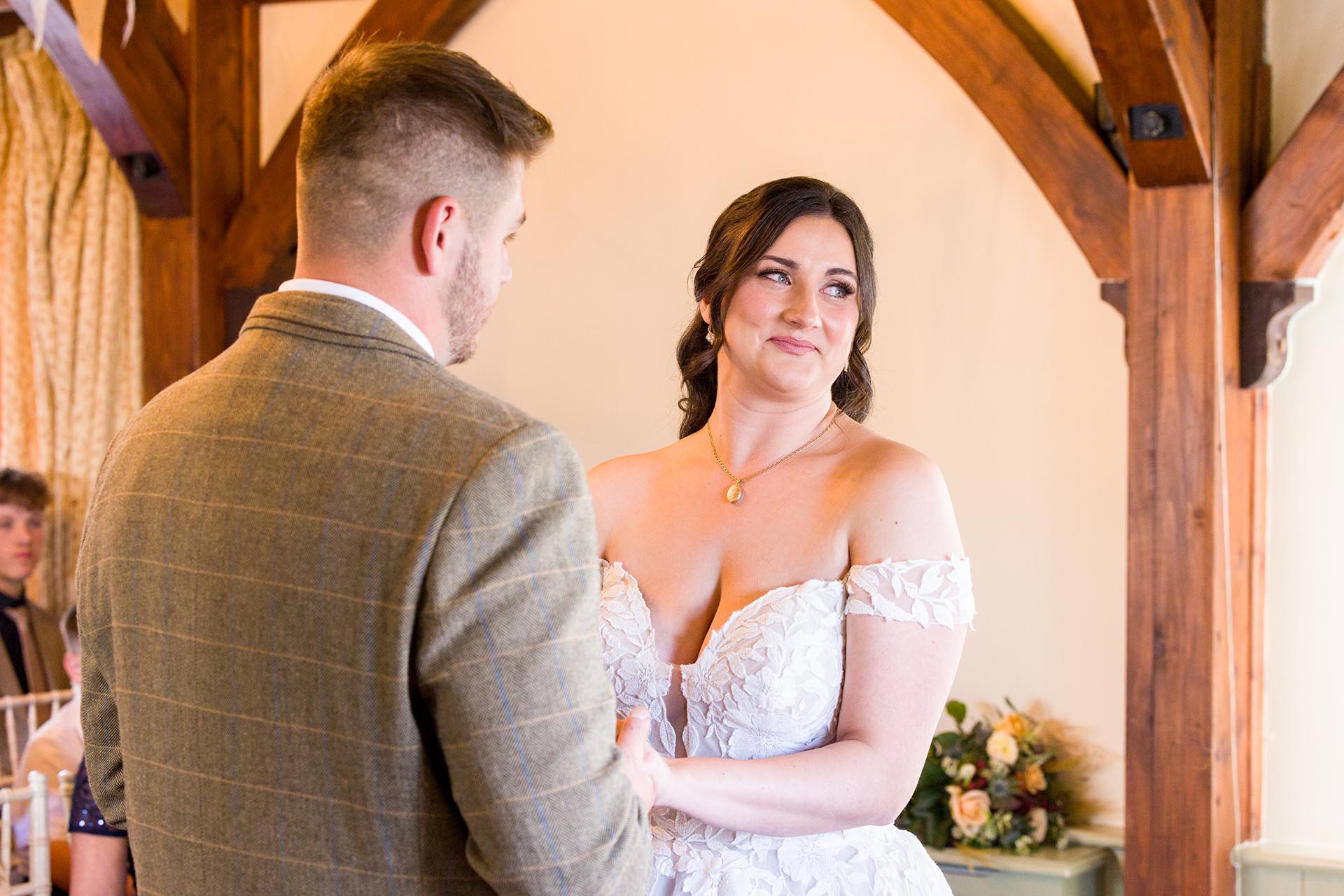 Photograph of bride smiling in the ceremony room at The Compasses at Pattiswick, Essex