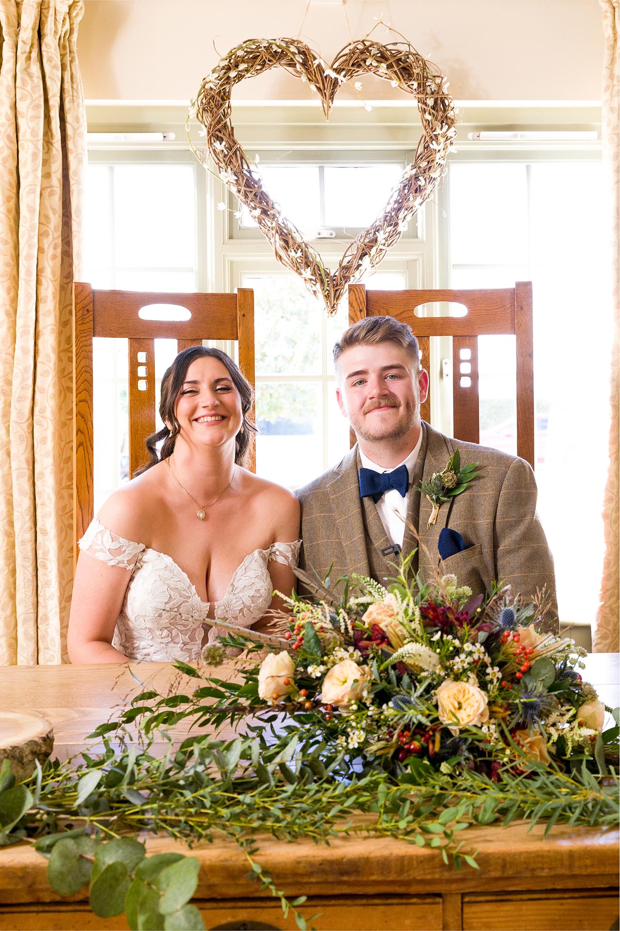 Photograph of bride and groom smiling in the ceremony room at The Compasses at Pattiswick, Essex