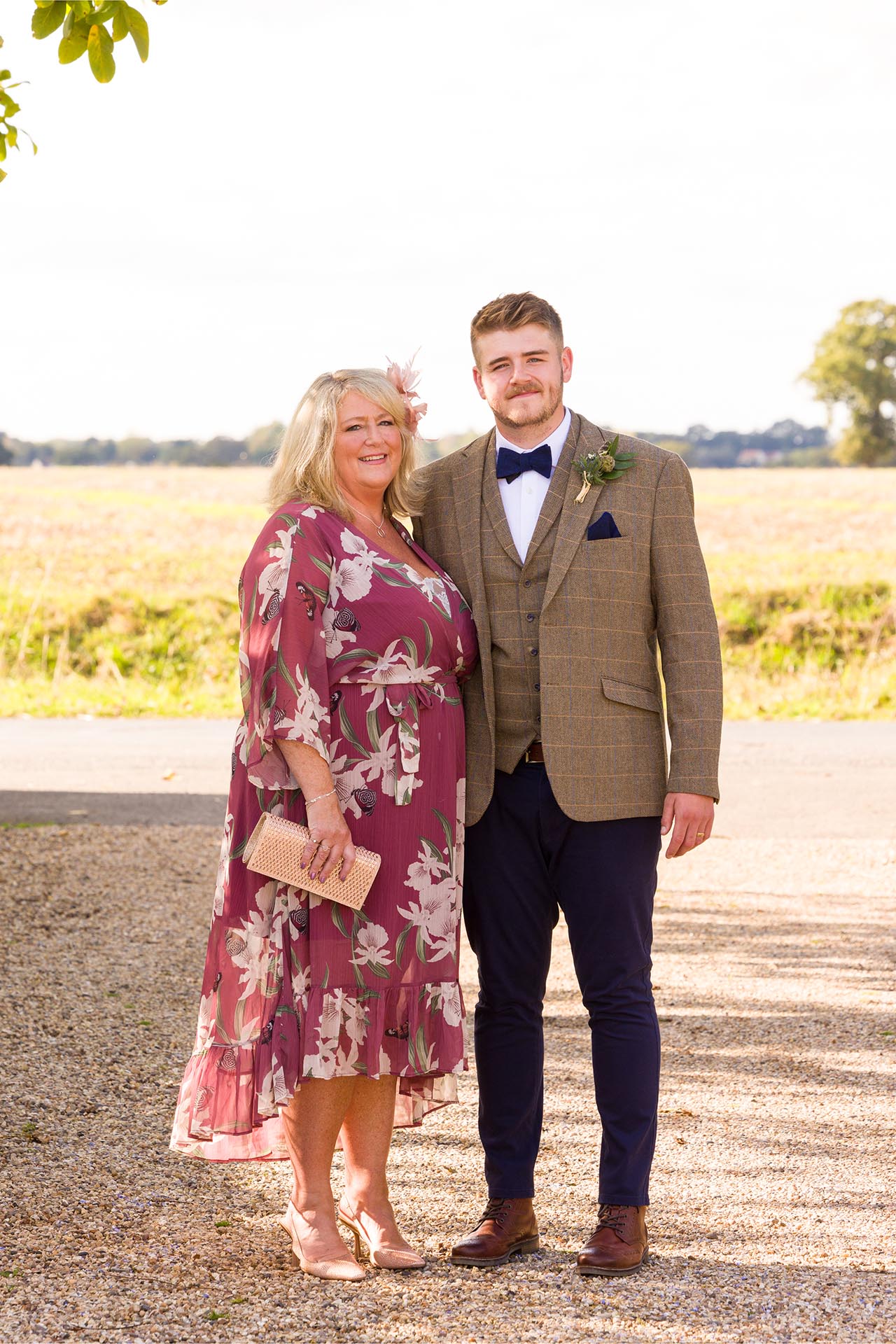 Photograph groom with a guest infront of fields at The Compasses at Pattiswick wedding venue