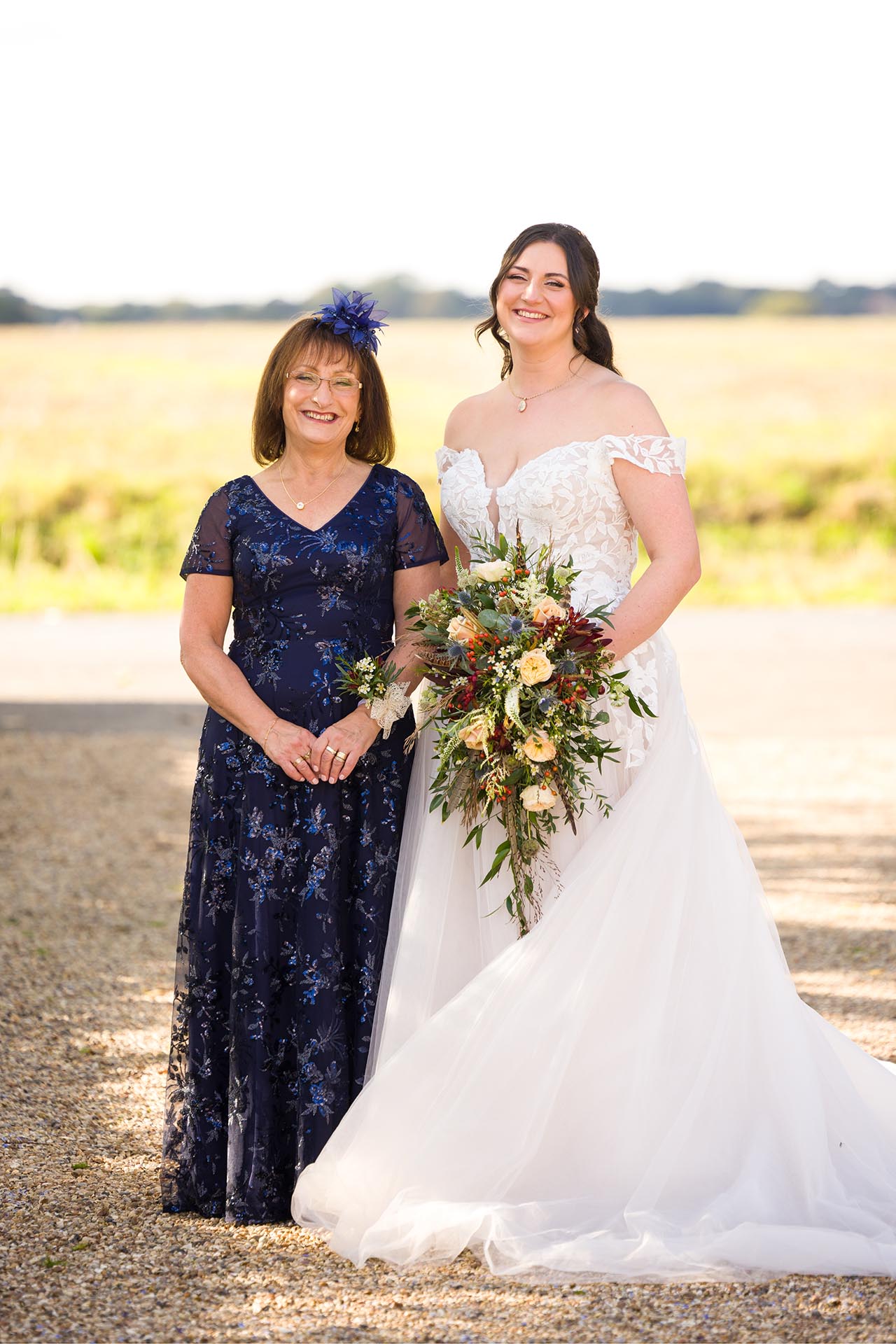 Photograph bride and her mother infront of fields at The Compasses at Pattiswick wedding venue