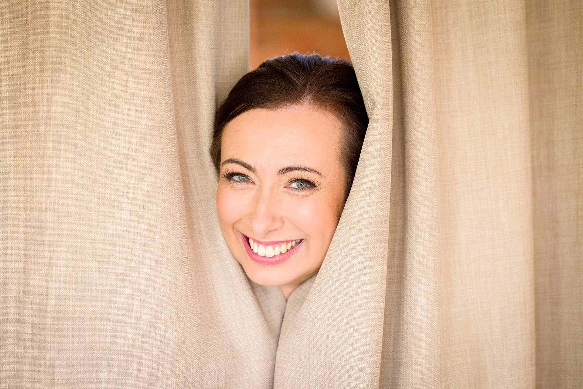 Photograph of wedding guest peeking through curtains