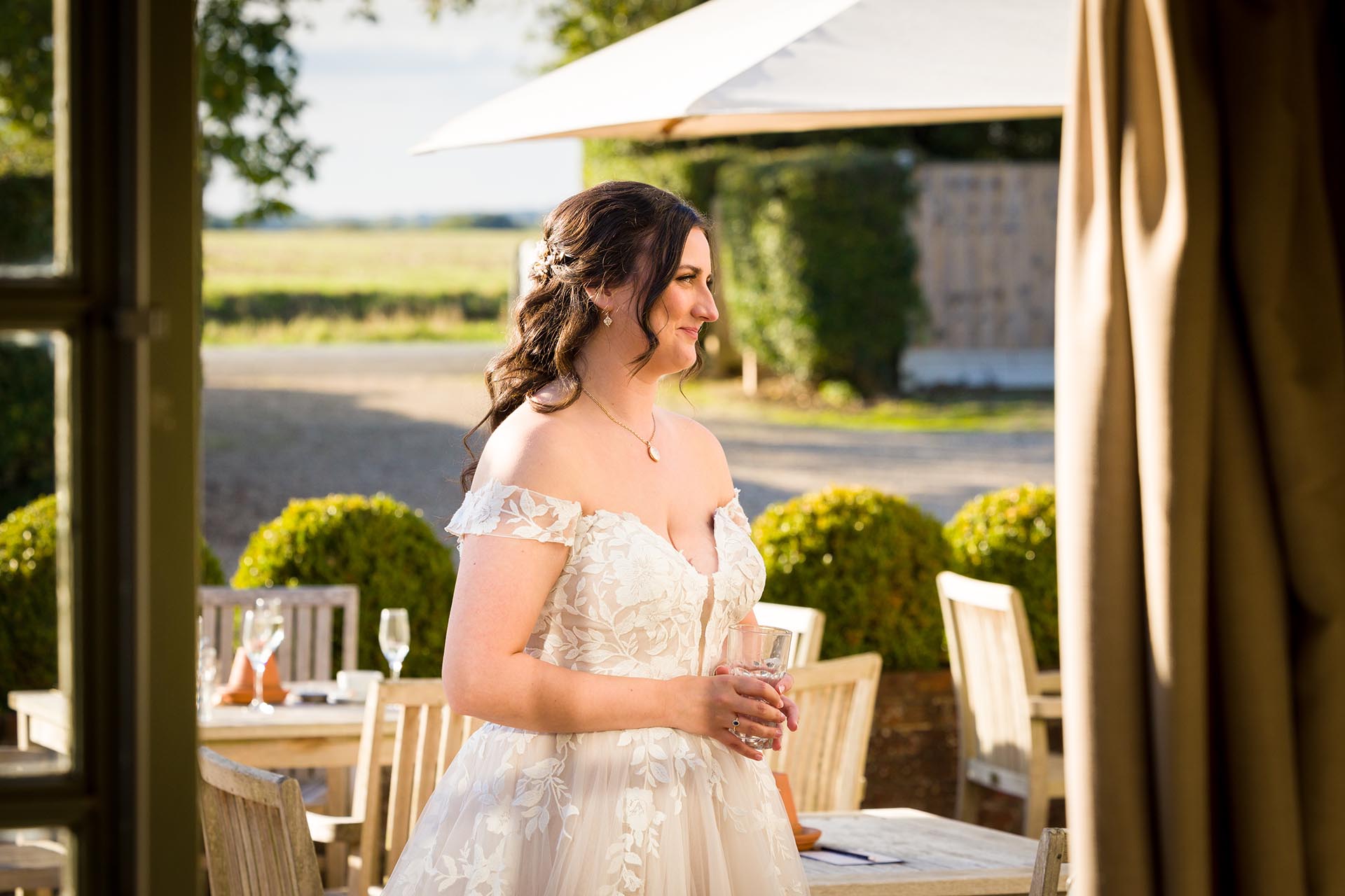 Photograph of bride smiling in the sunshine at The Compasses at Pattiswick
