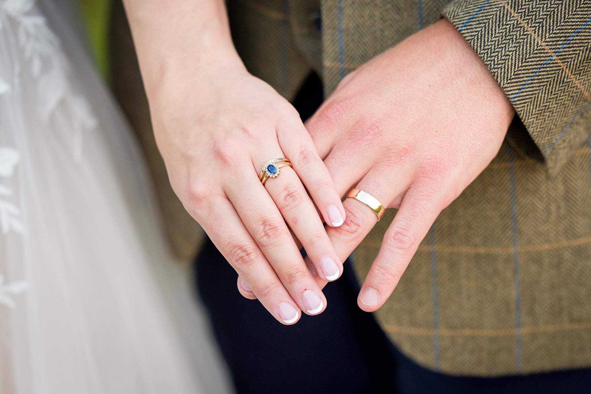 Close-up photograph of brideand groom's hands showing their wedding rings