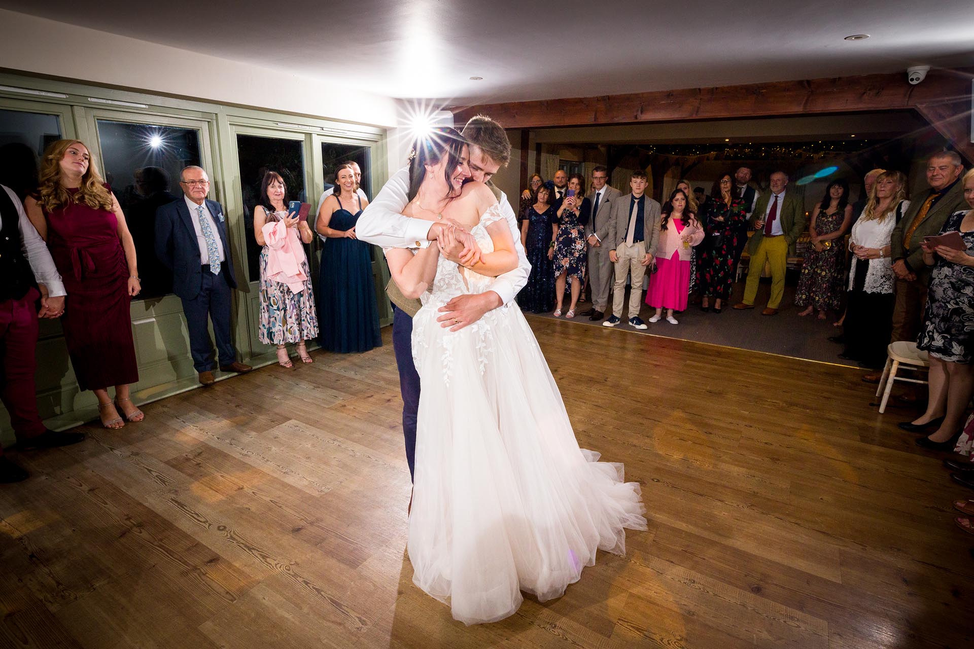Photograph of bride and groom's first dance infront of guests at The Compasses at Pattiswick