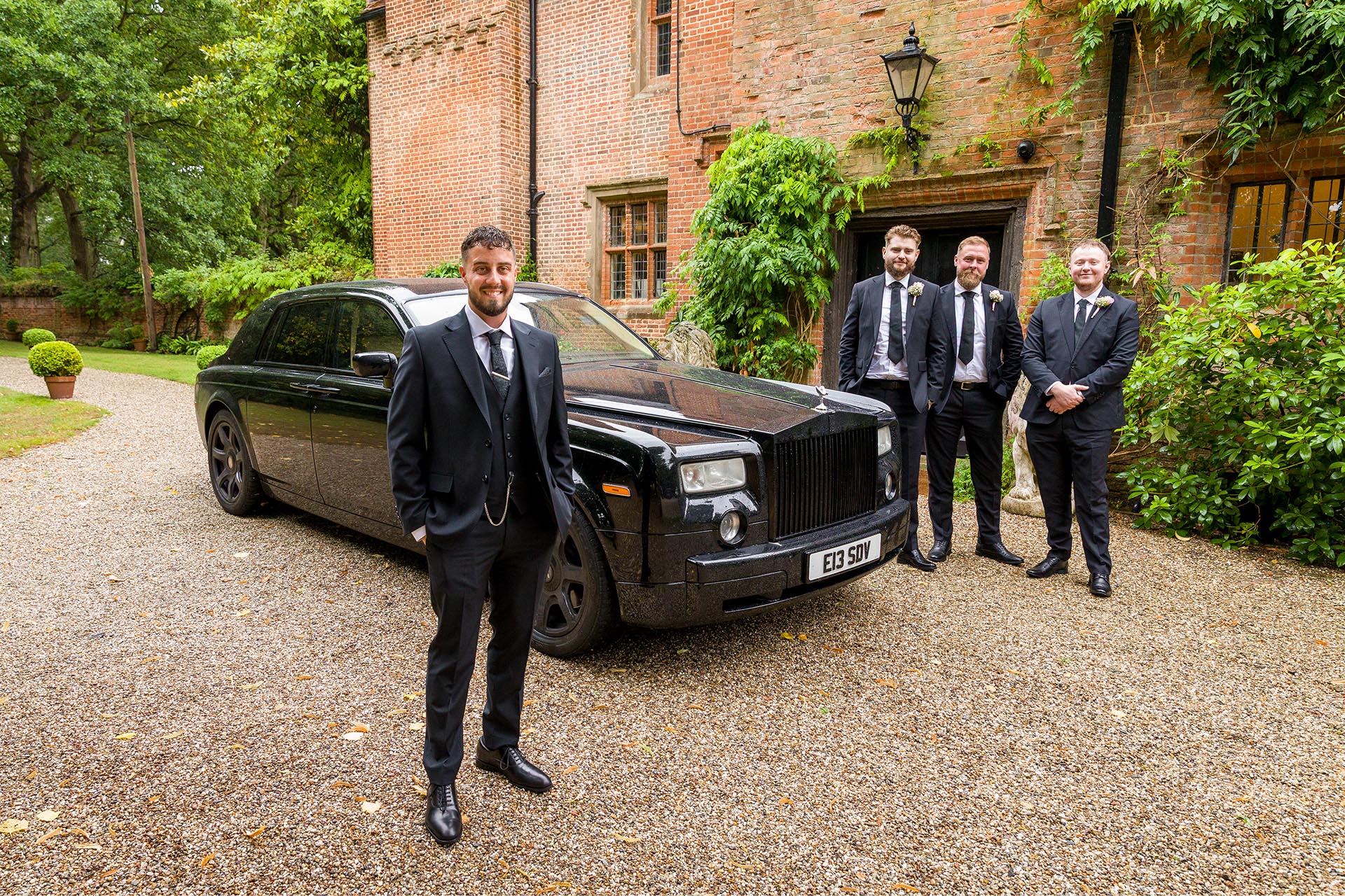 Photograph of groom and his groomsmen with a black Rolls-Royce wedding car at Creeksea Place, Burnham-on-Crouch, Essex