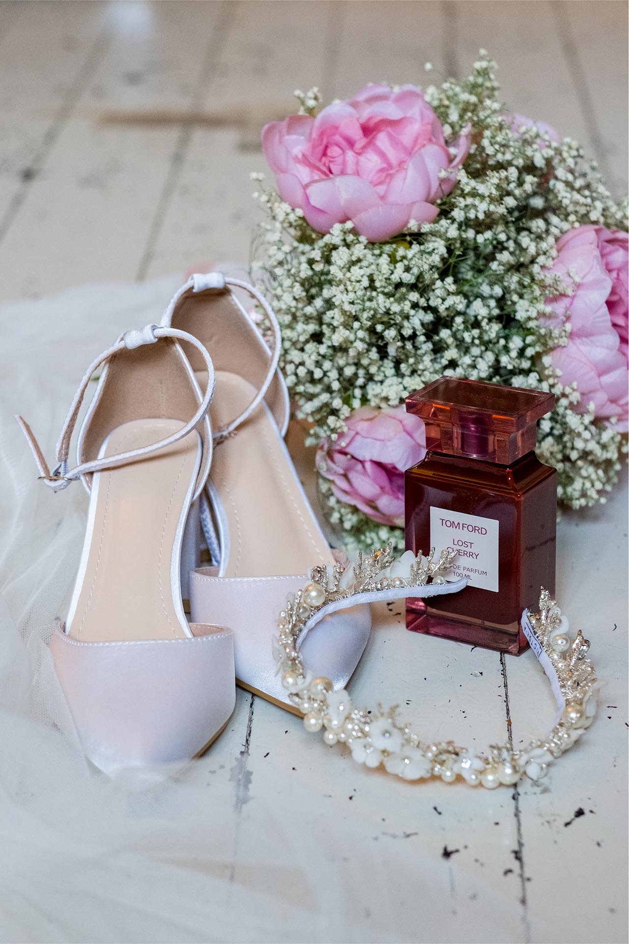 Photograph of bride's wedding accessories including shoes, tiara, flowers and perfume