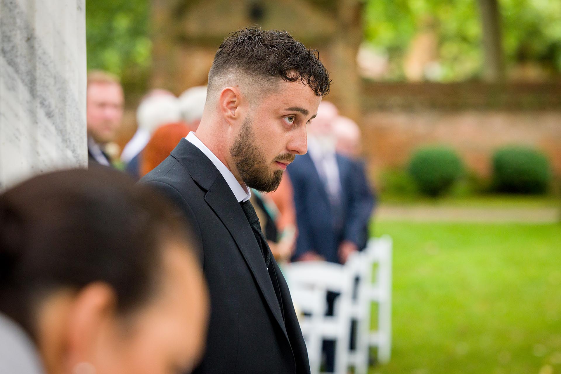 Photograph of groom waiting for his bride to arrive for outdoor ceremony